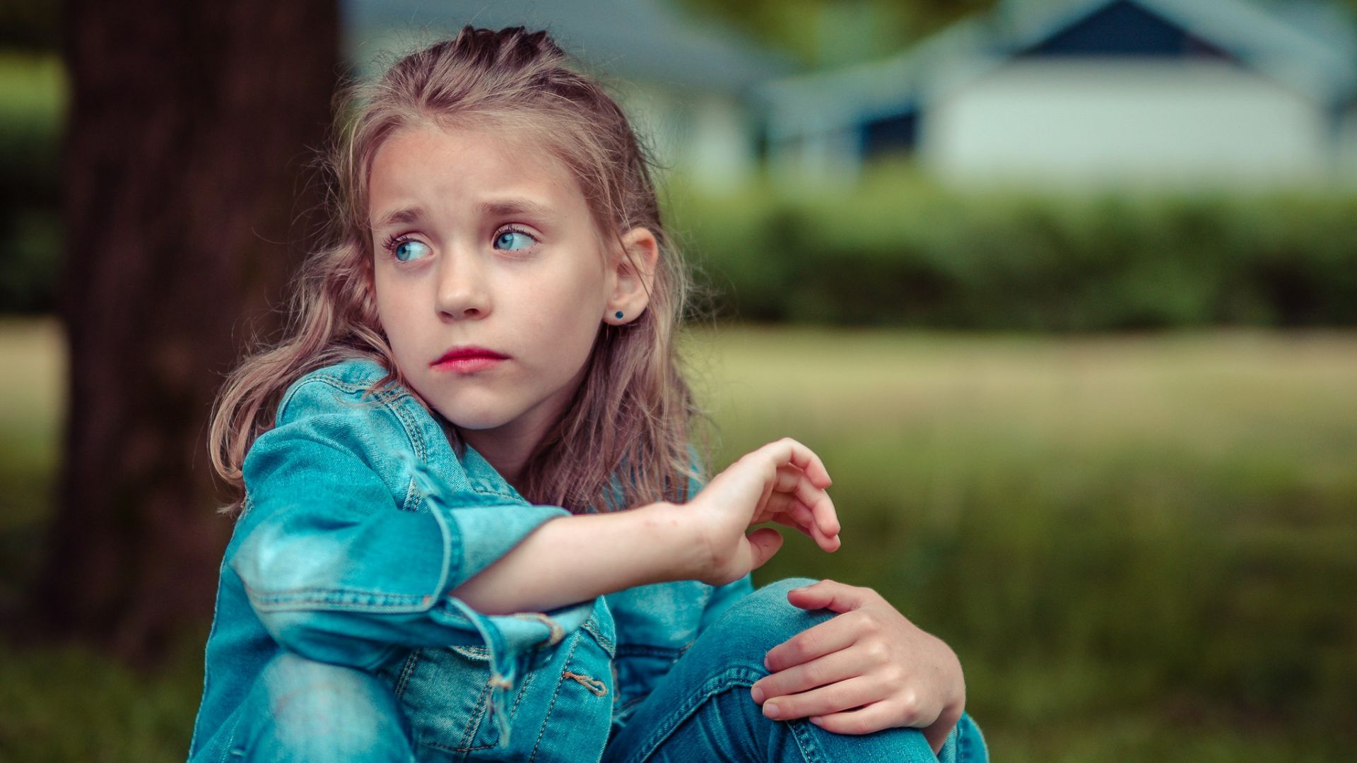 selective focus photography of girl sitting near tree