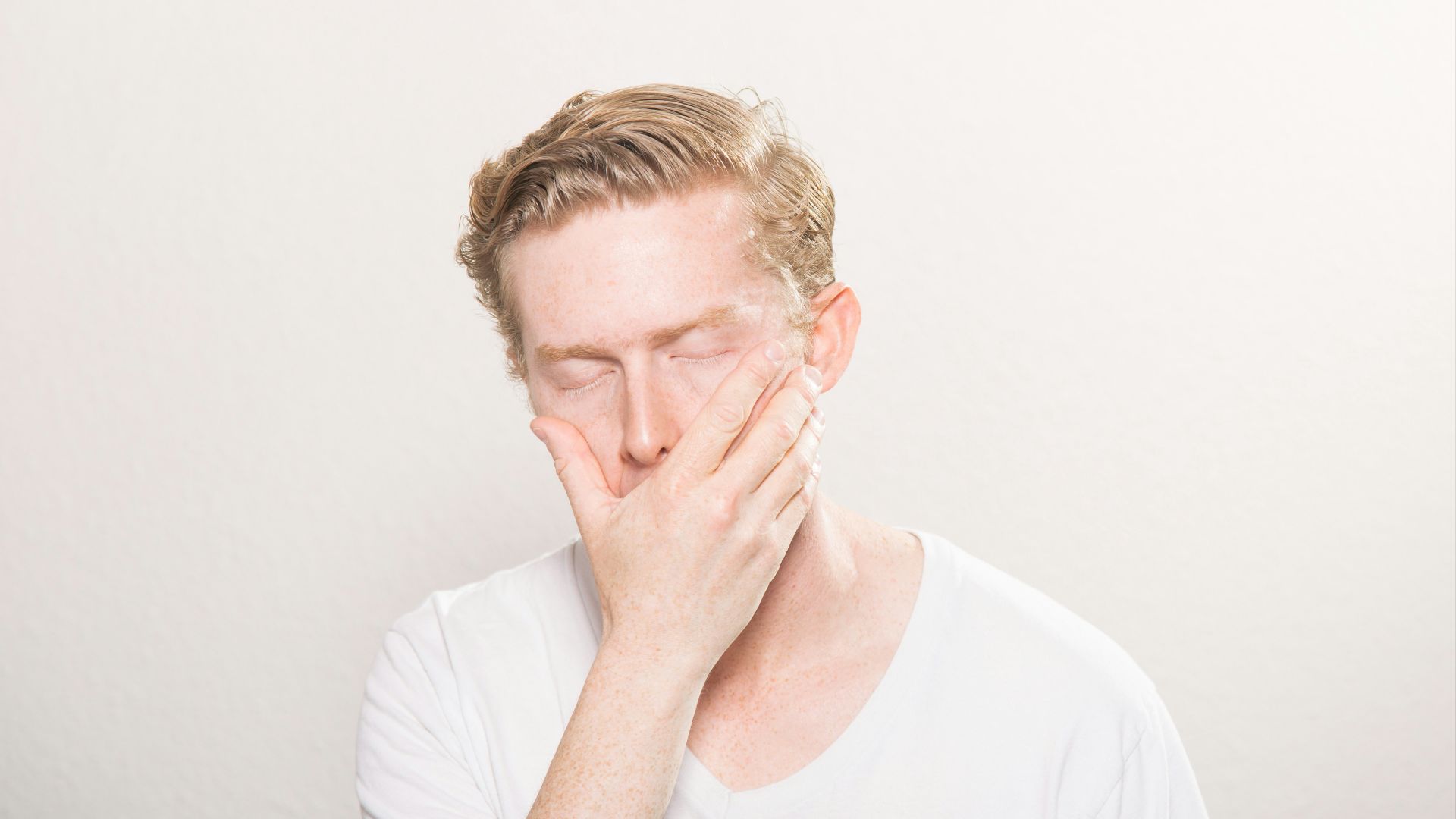 man covering his mouth