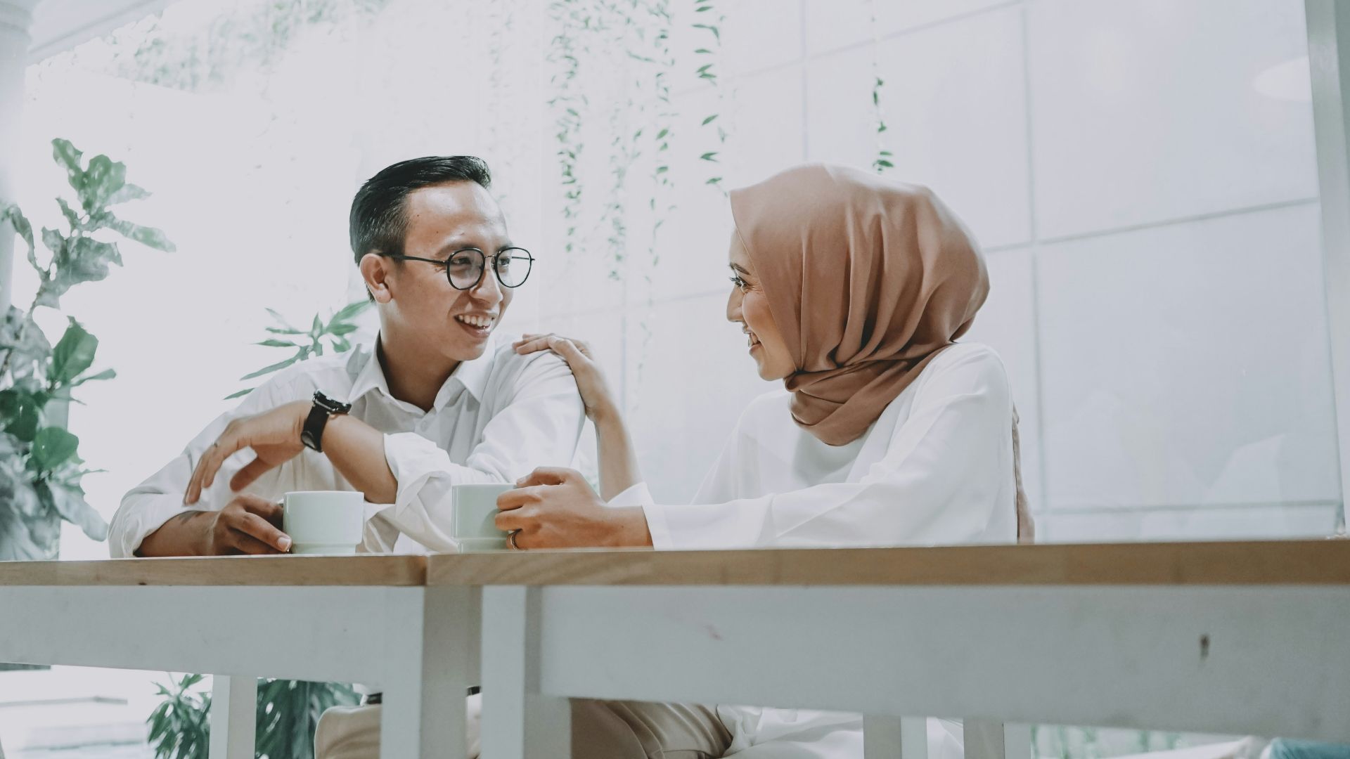 man in white dress shirt sitting on brown wooden chair