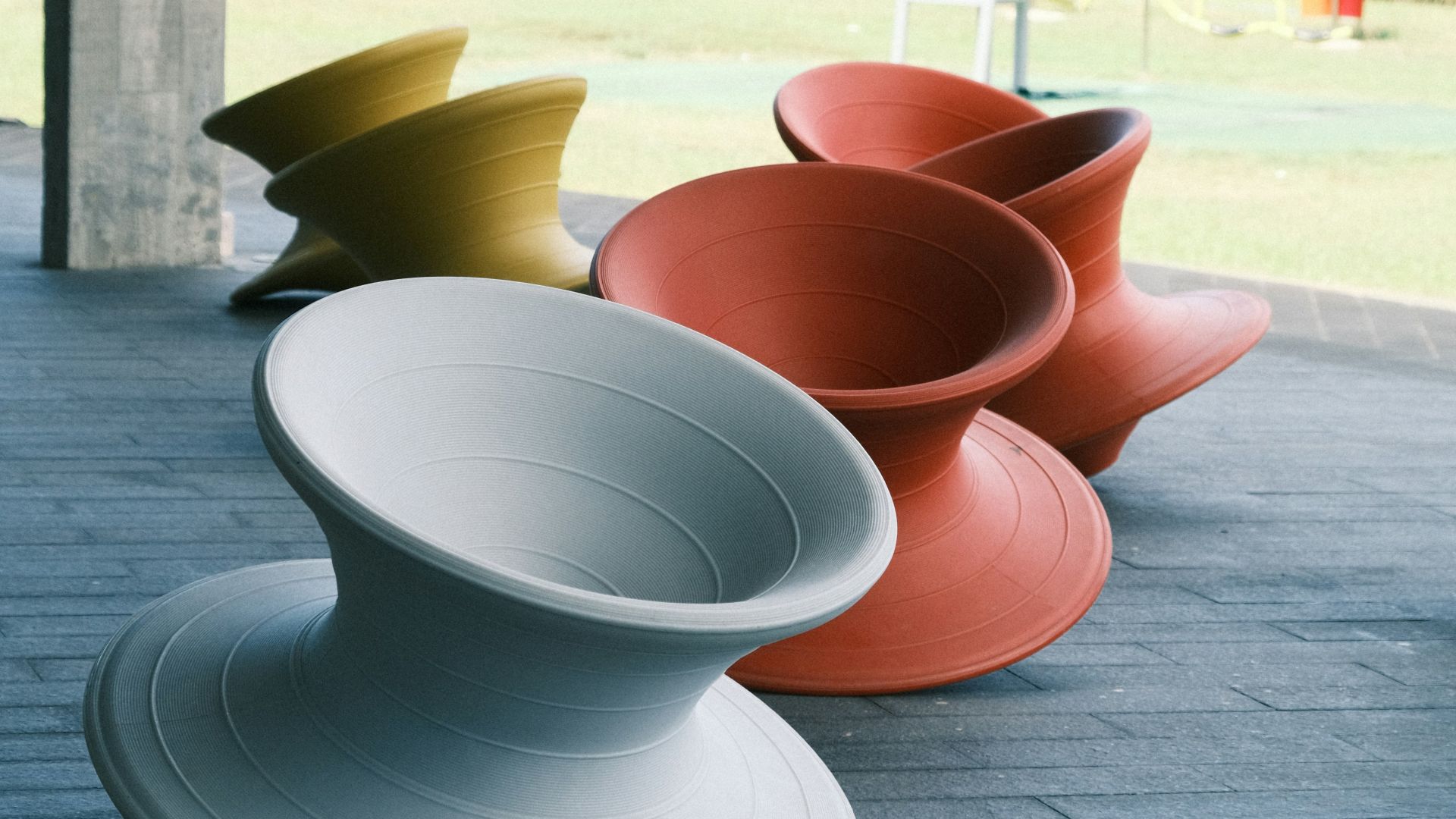 A row of colorful bowls sitting on top of a sidewalk