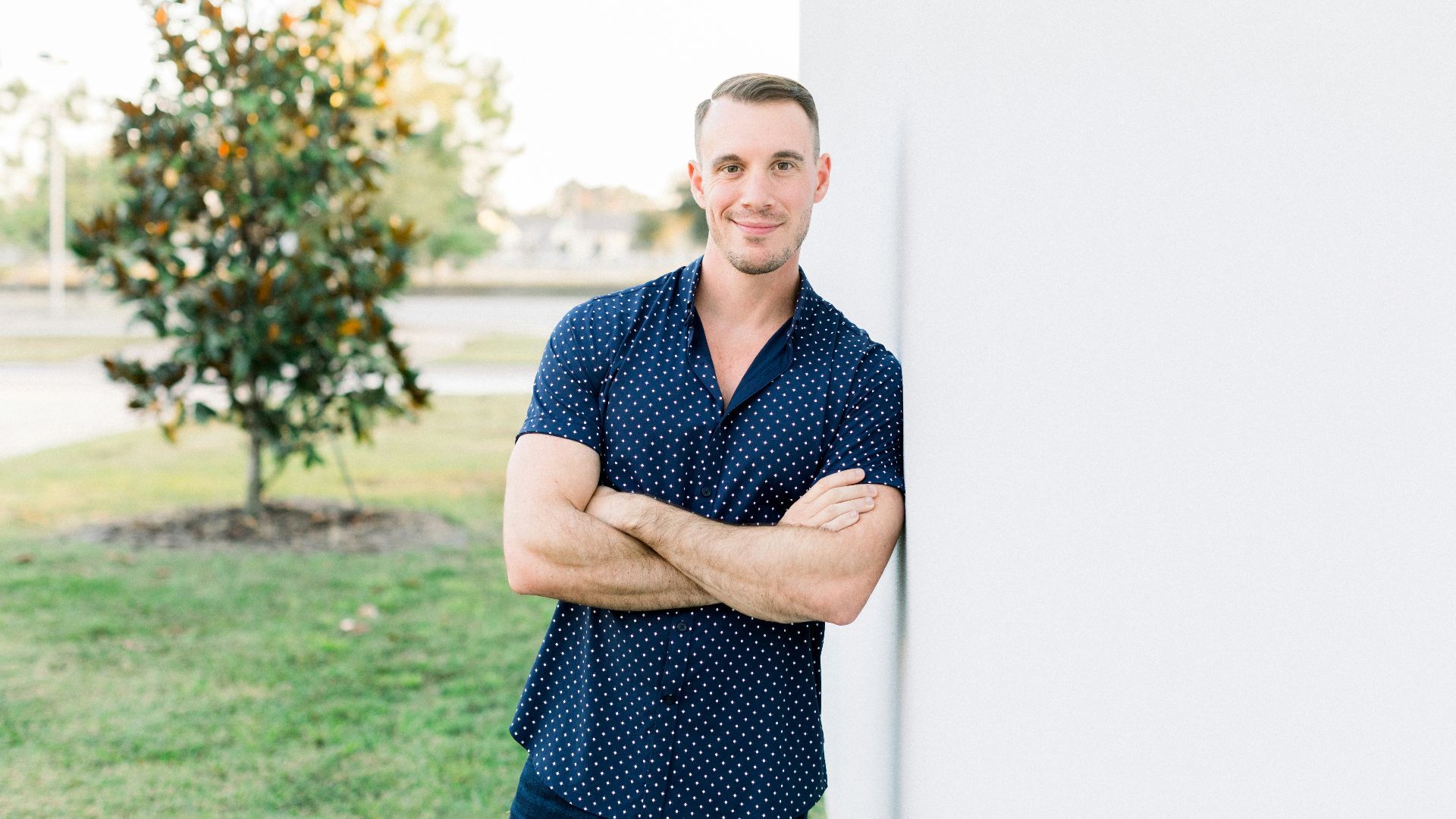 a man leaning against a wall with his arms crossed
