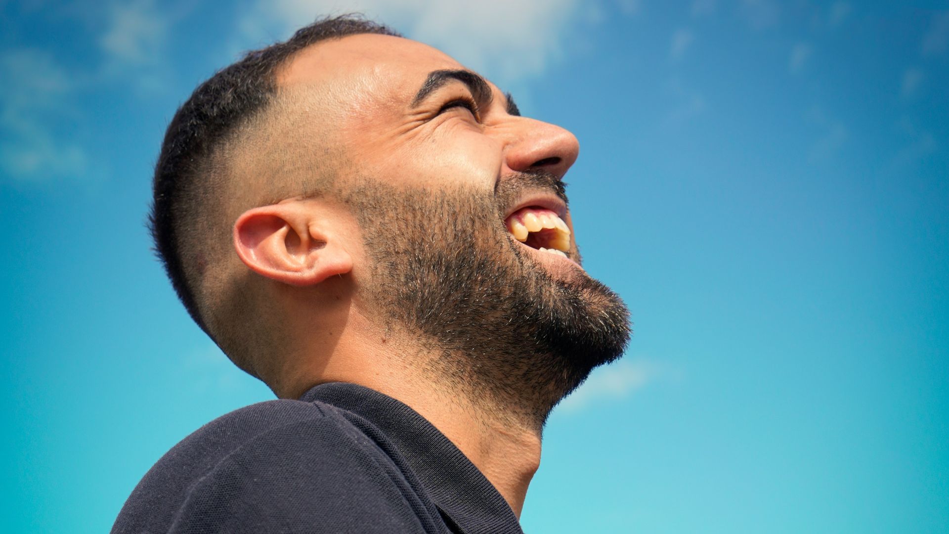smiling man wearing black collared top