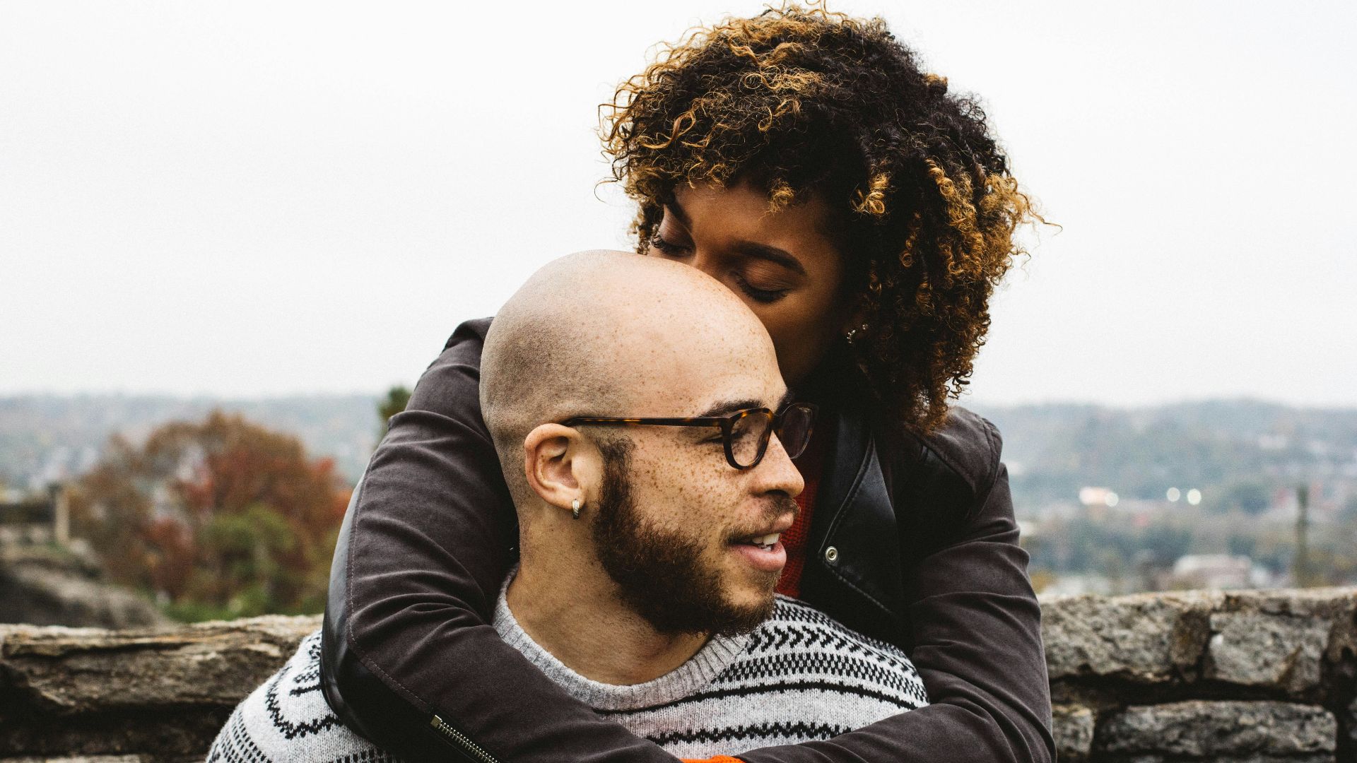 woman kissing man's head