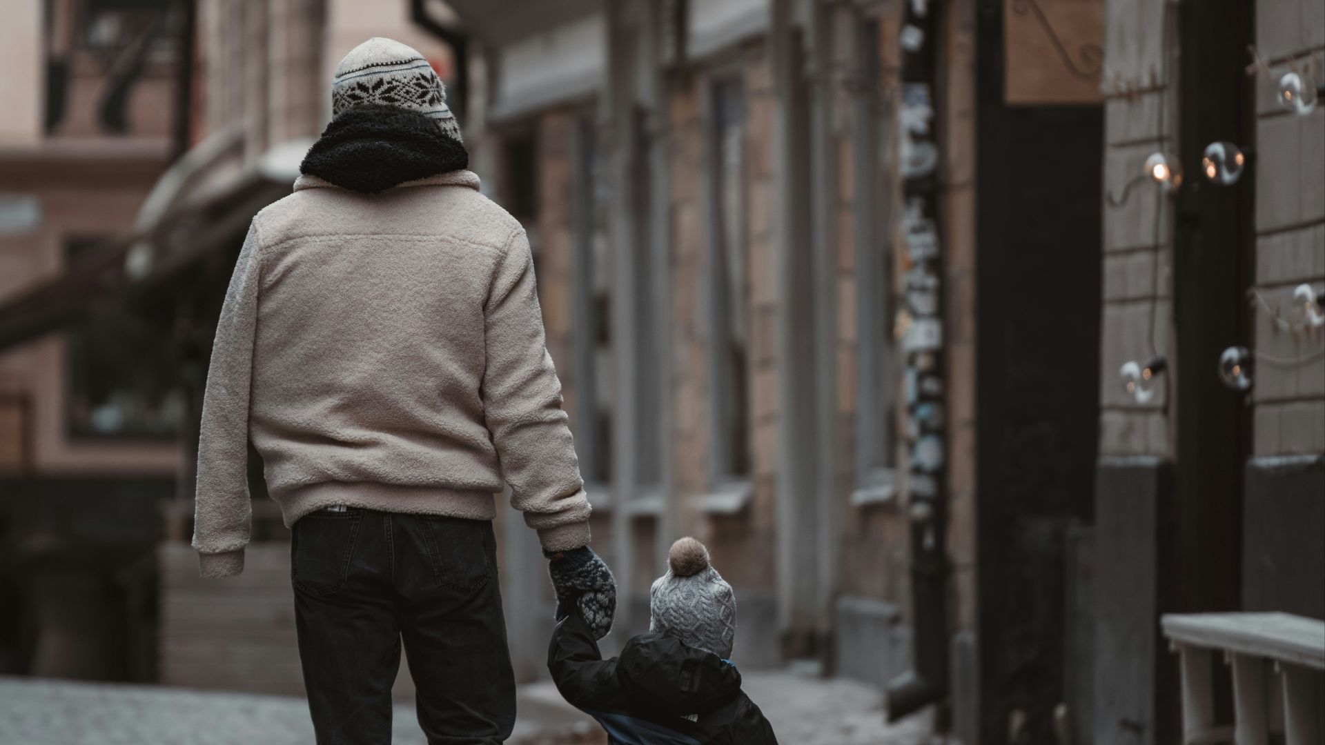 A man and a child walking down a street