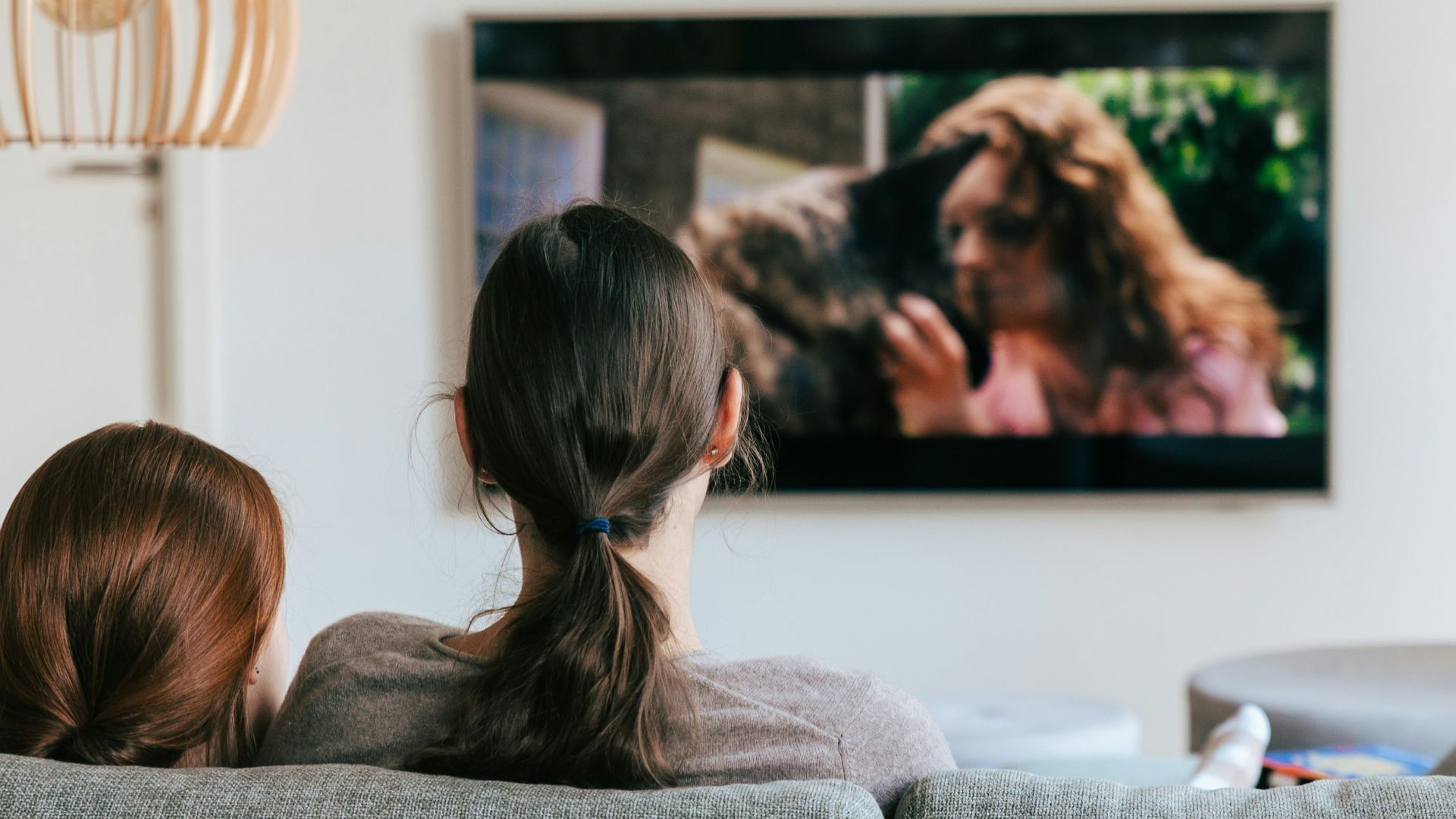 a couple of women sitting on top of a couch