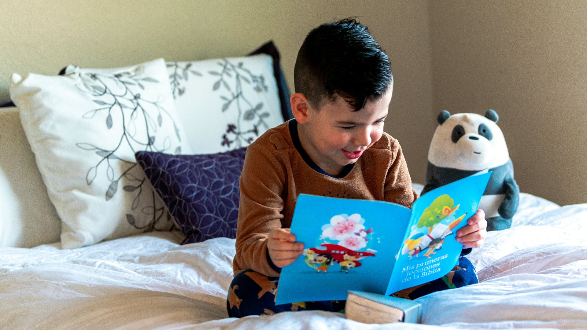 boy reading book on bed