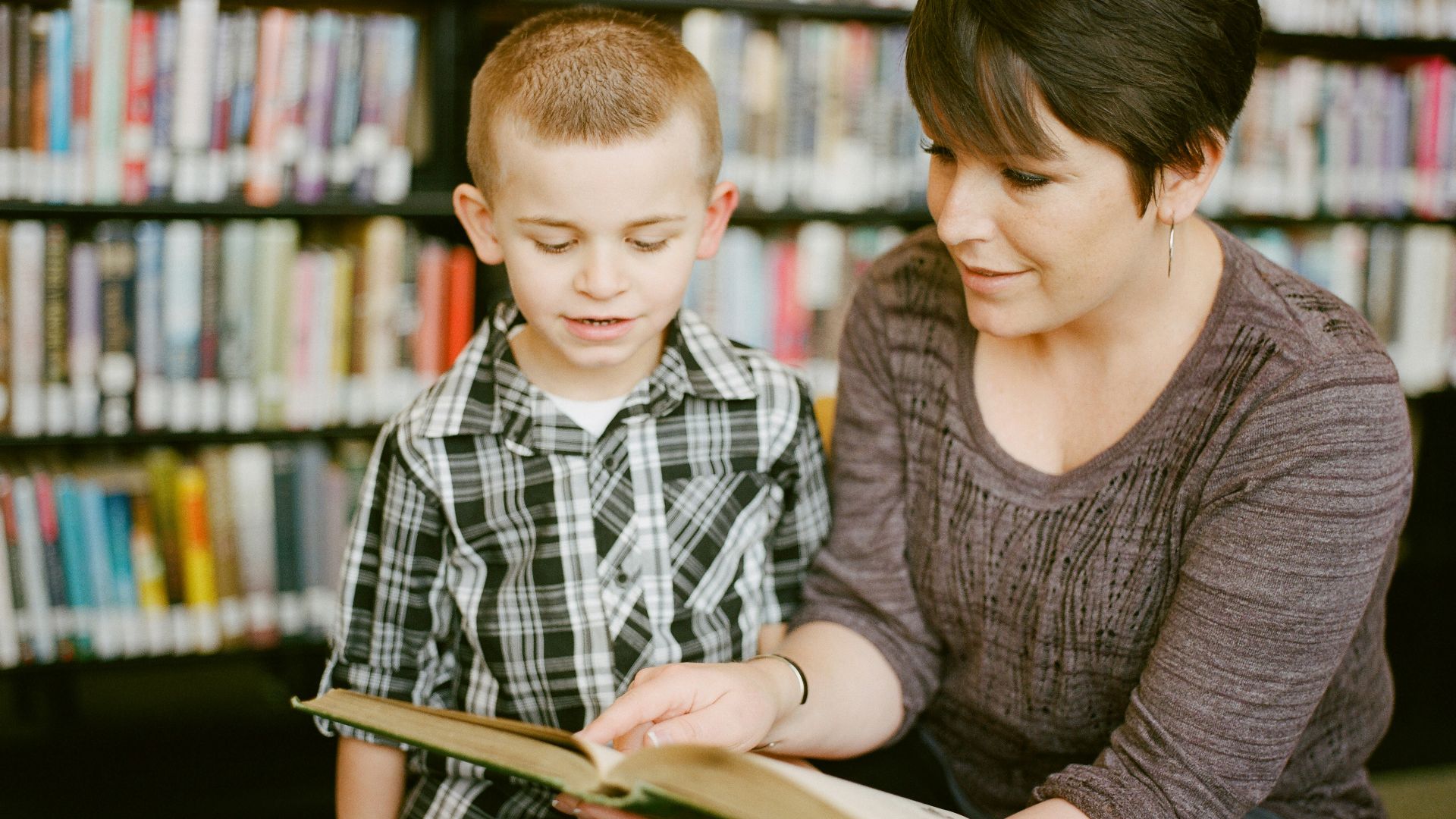 boy in gray sweater beside boy in gray and white plaid dress shirt
