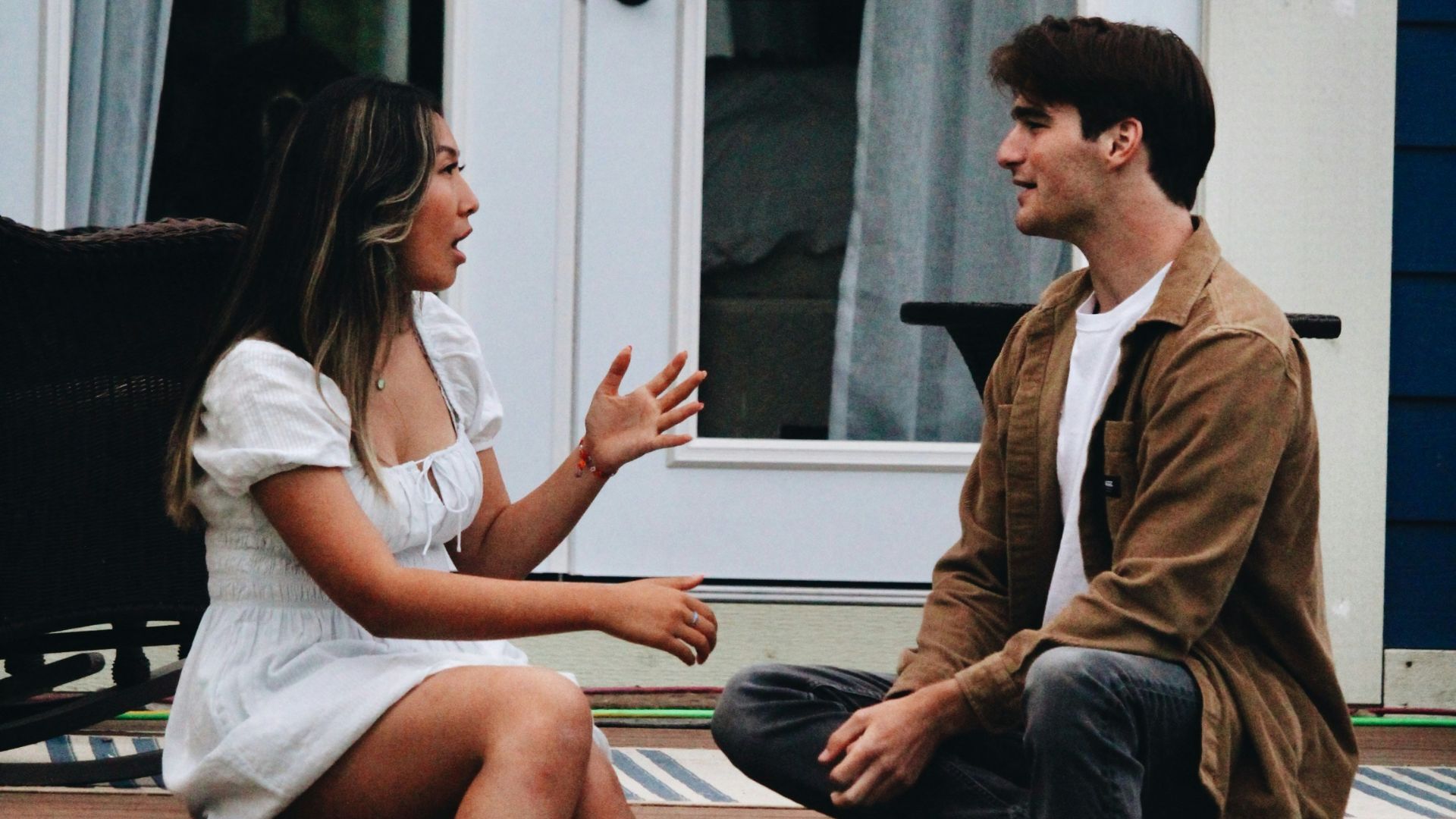 a man and woman sitting on a porch