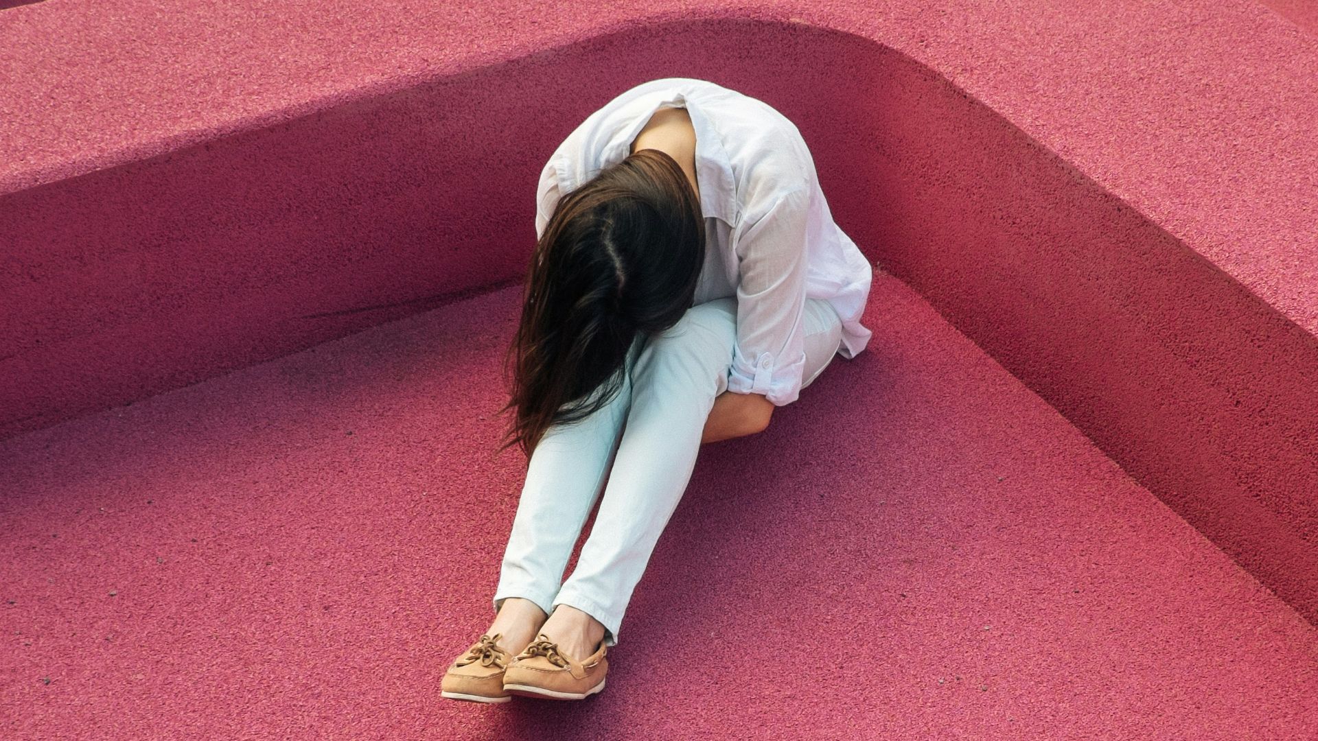 woman sitting leaning forehead on knee