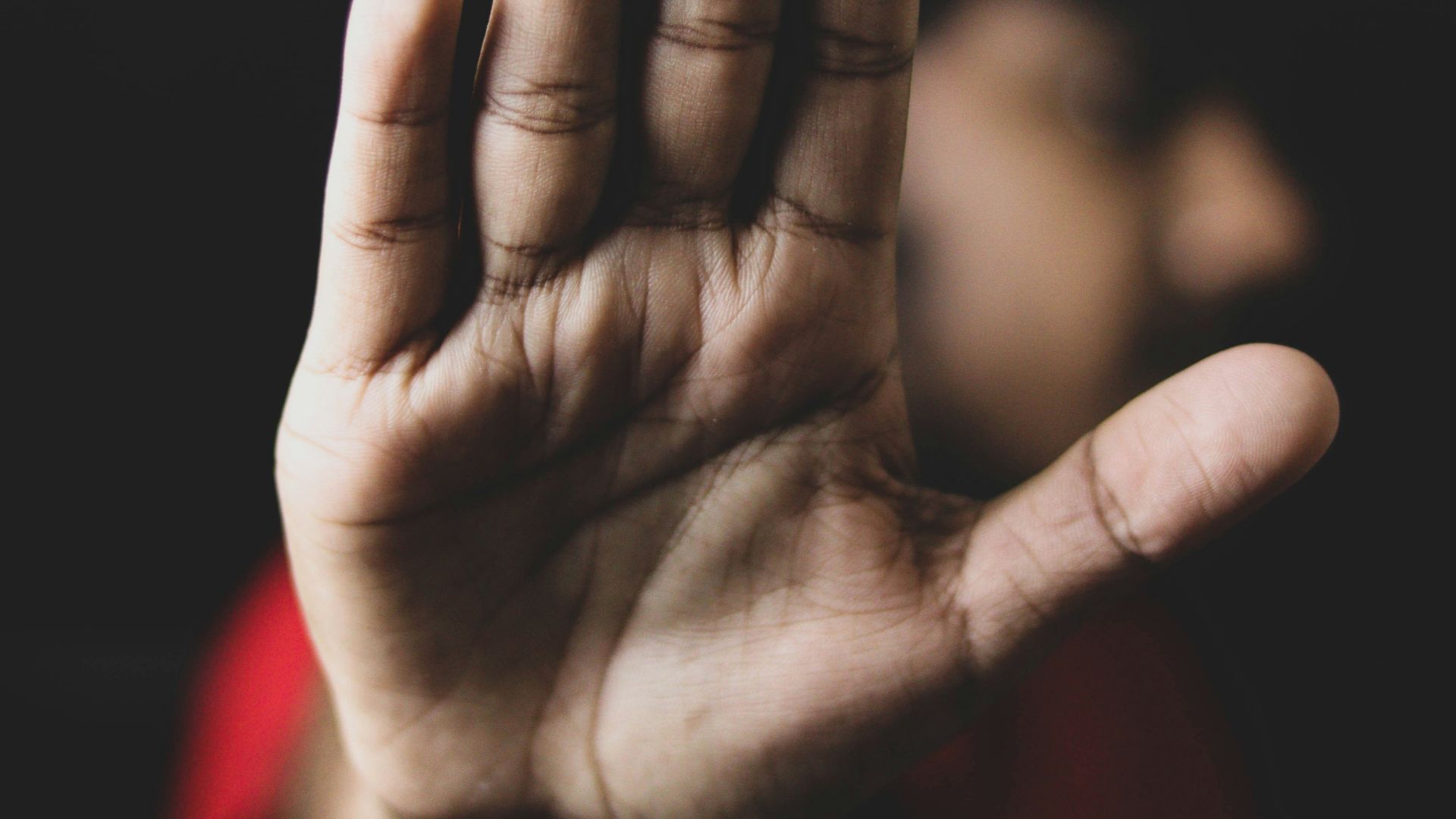 persons left hand on black background