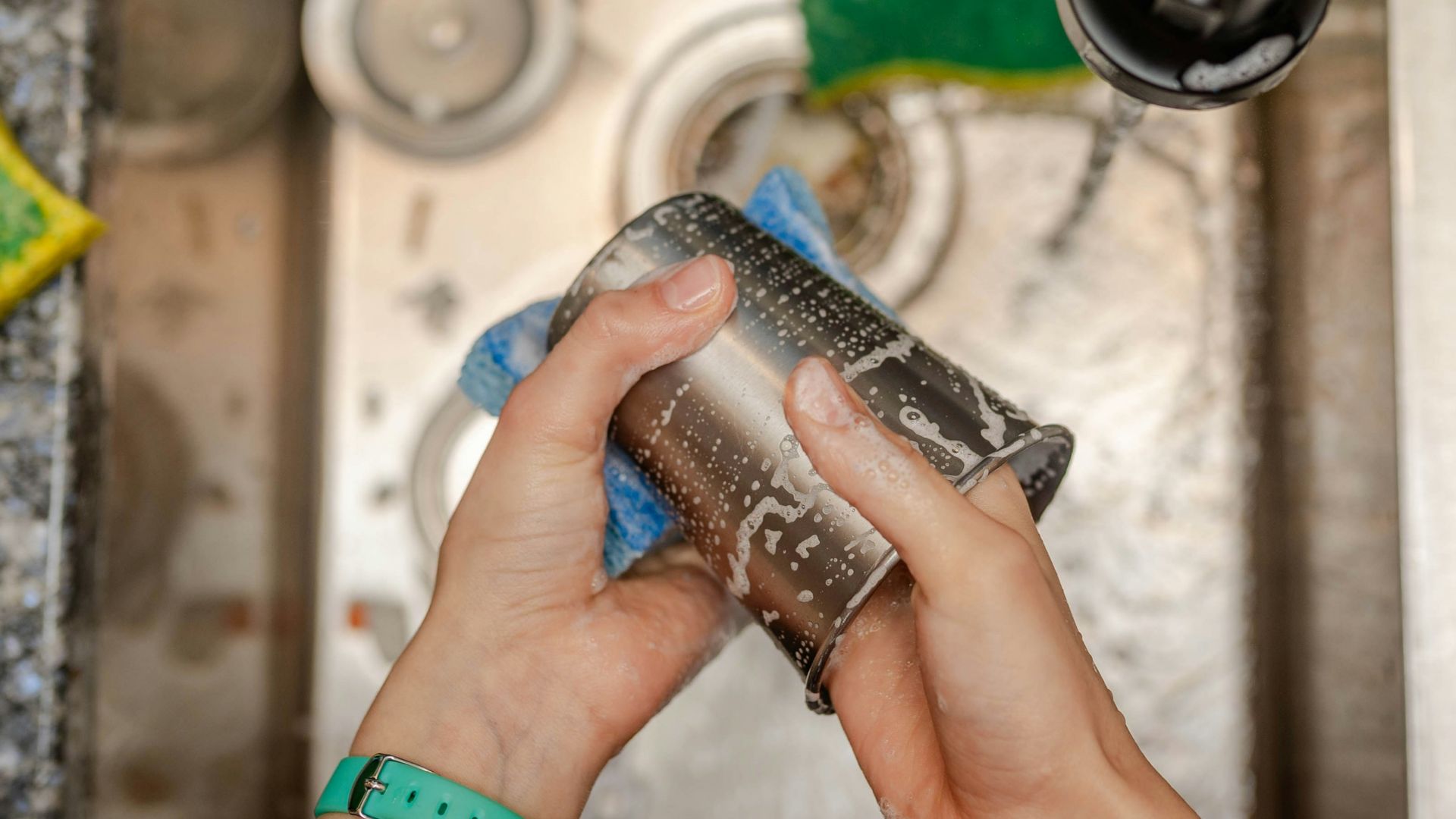 A person is cleaning a sink with a rag