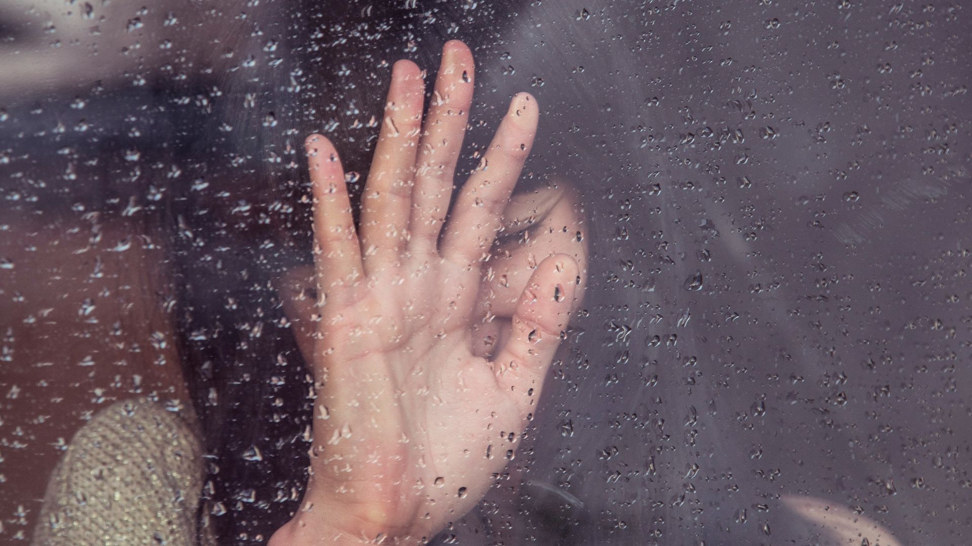 woman touch rainy glass