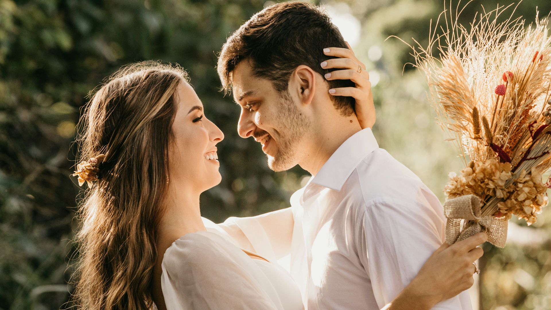 man in white dress shirt holding brown flower bouquet