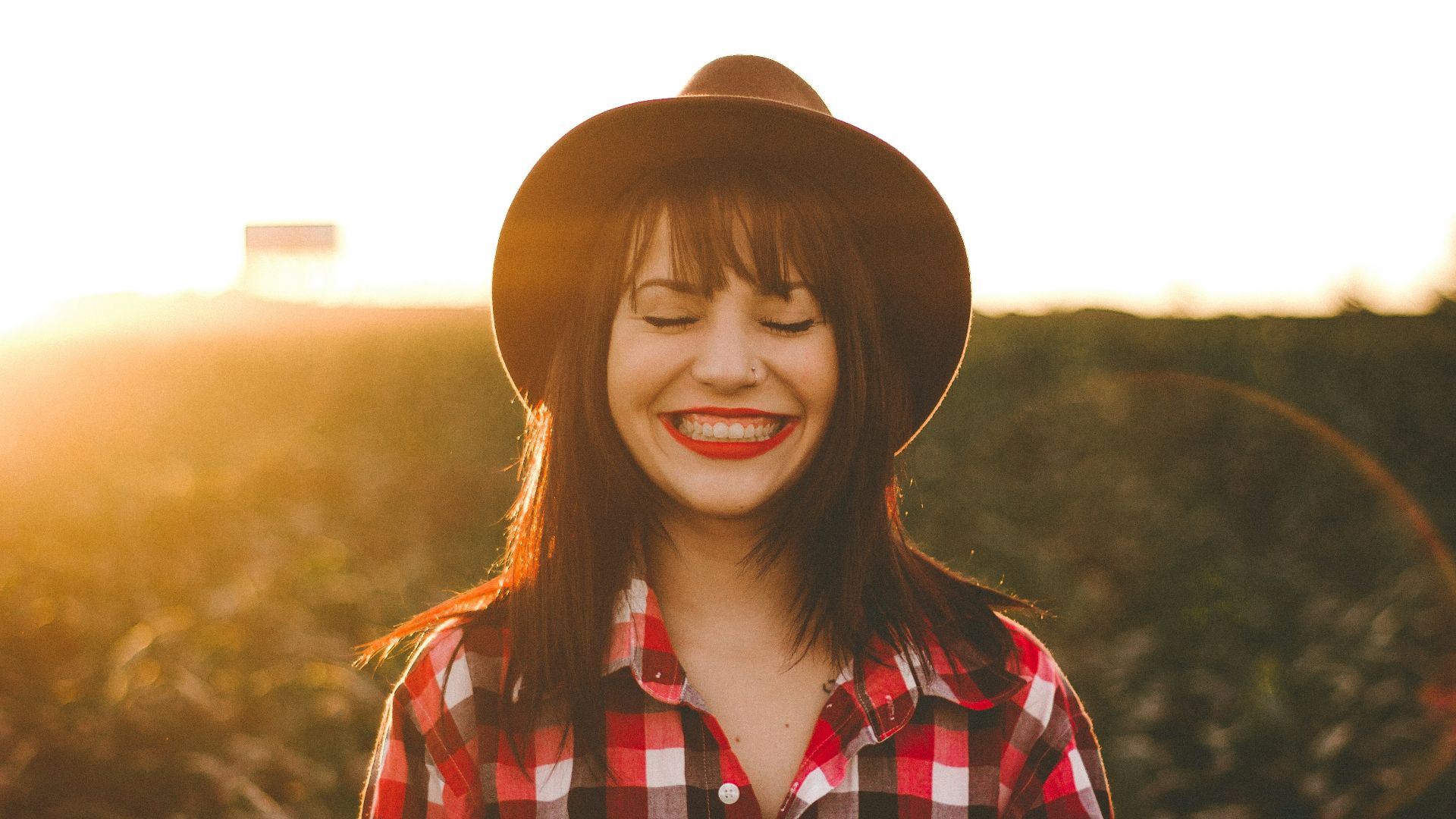 golden hour photography of woman in red and white checkered dress shirt