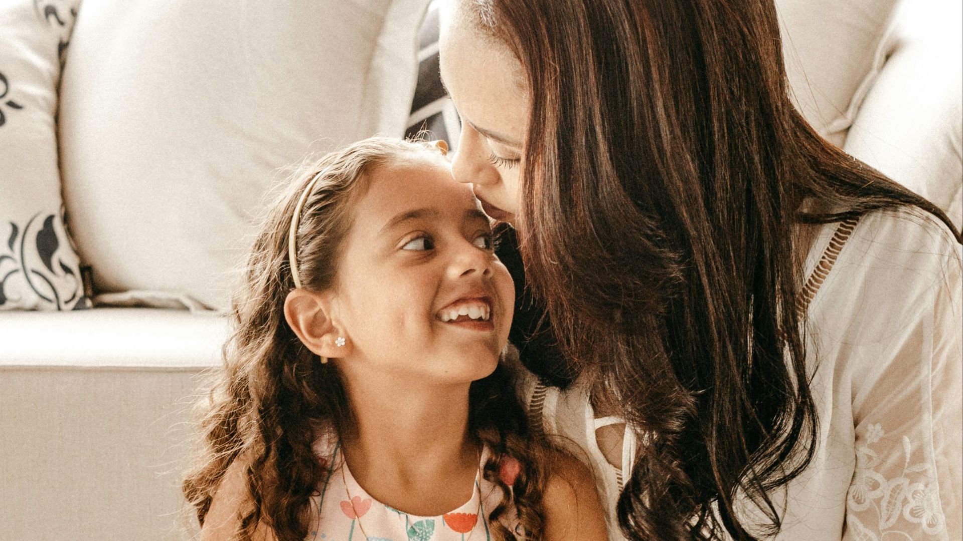 a woman sitting on the floor with a little girl