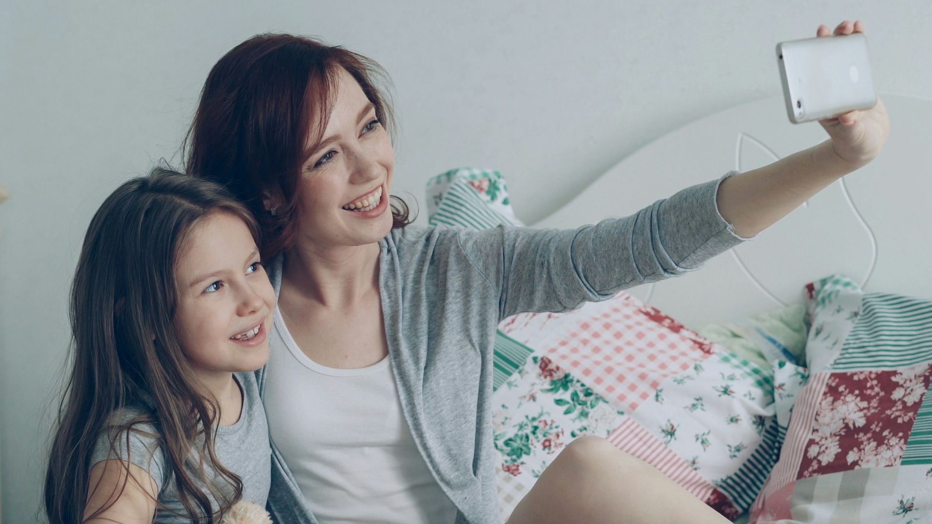 Mother and daughter take a selfie together.