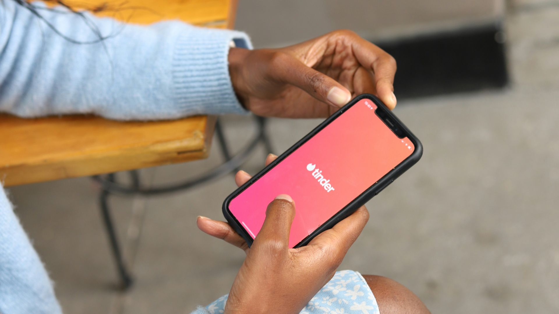 a woman sitting on a bench holding a cell phone