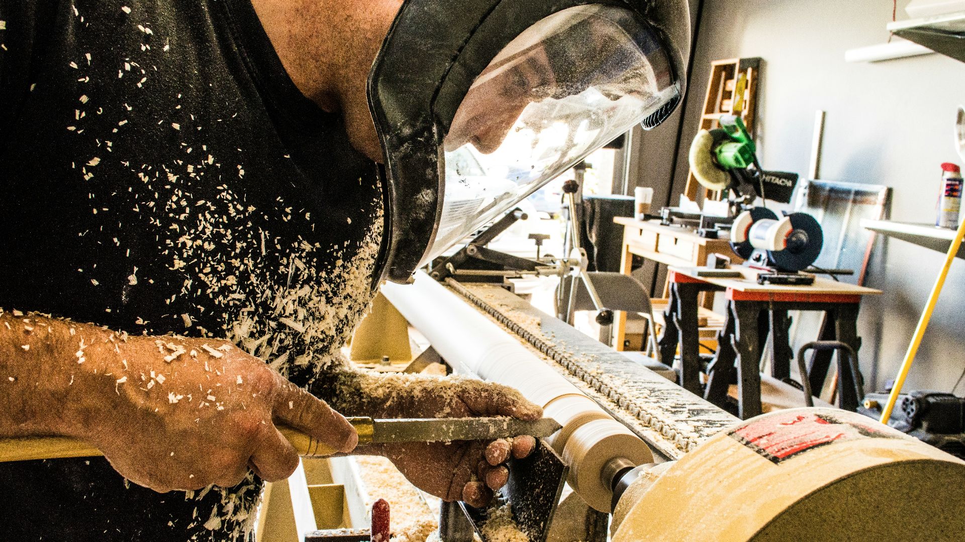 man wearing welding helmet in front of industrial machine