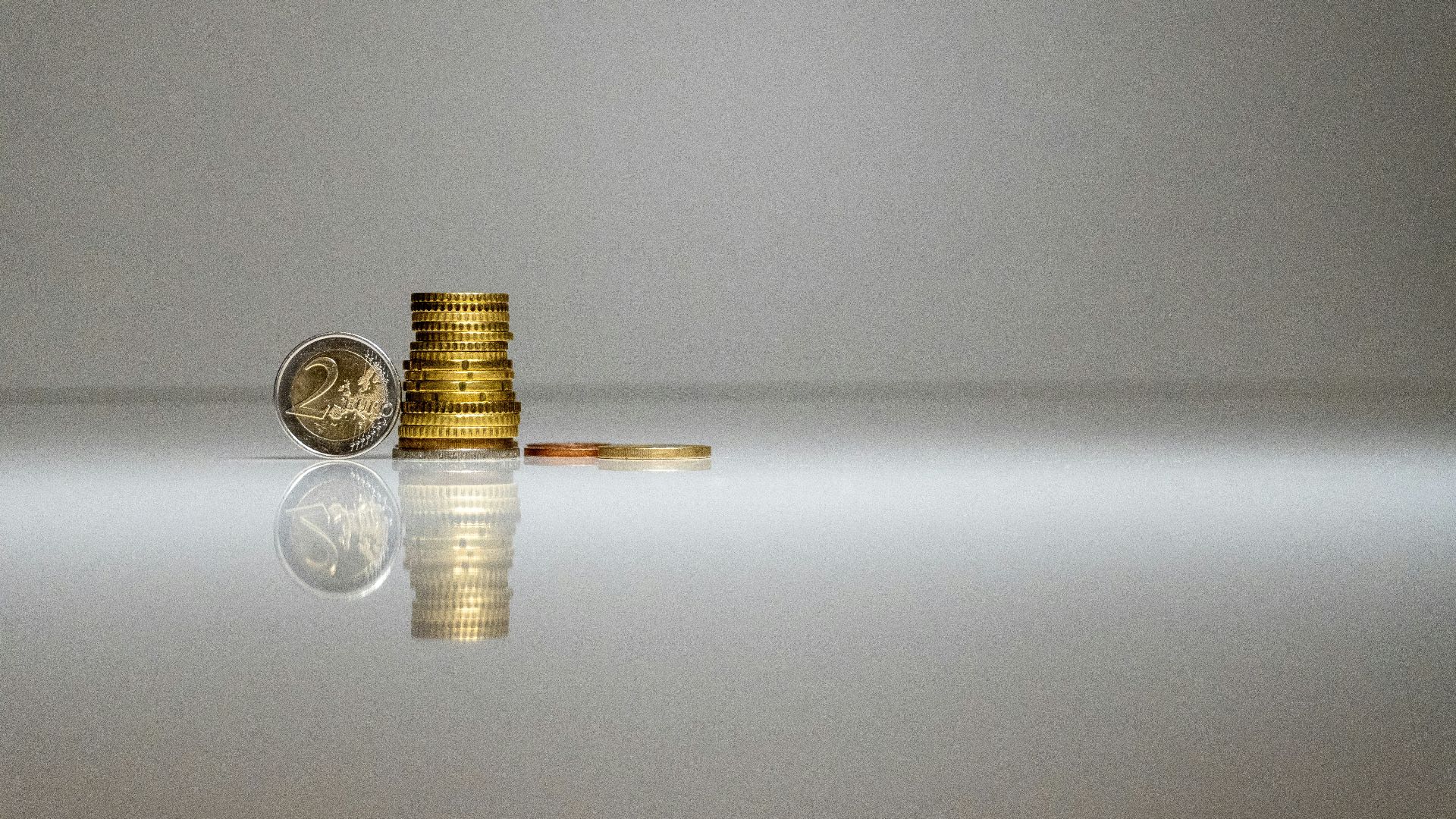 a stack of coins sitting on top of a reflective surface