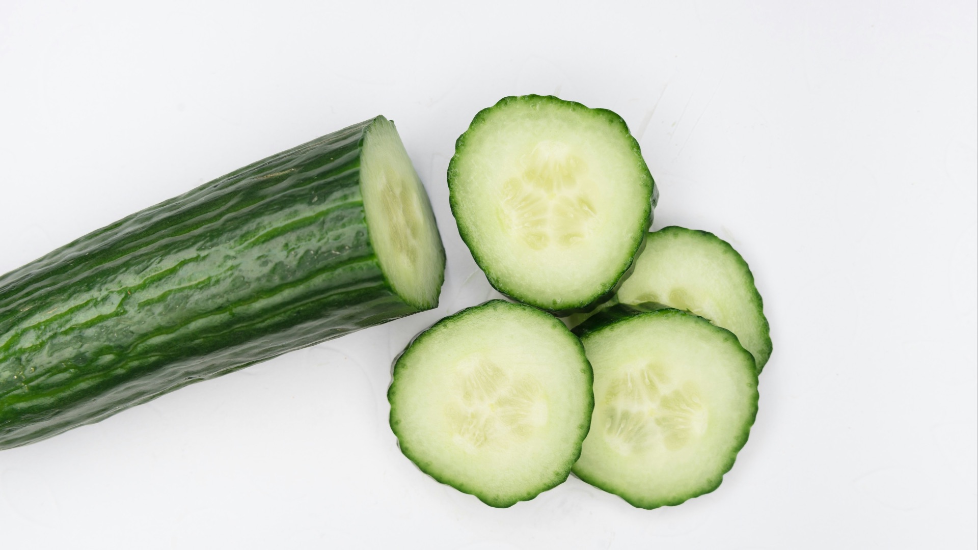 sliced cucumber on white surface