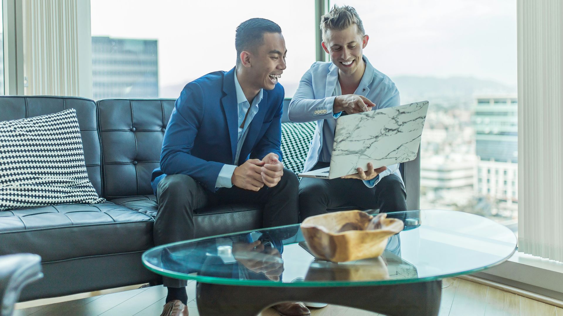 two men in suit sitting on sofa