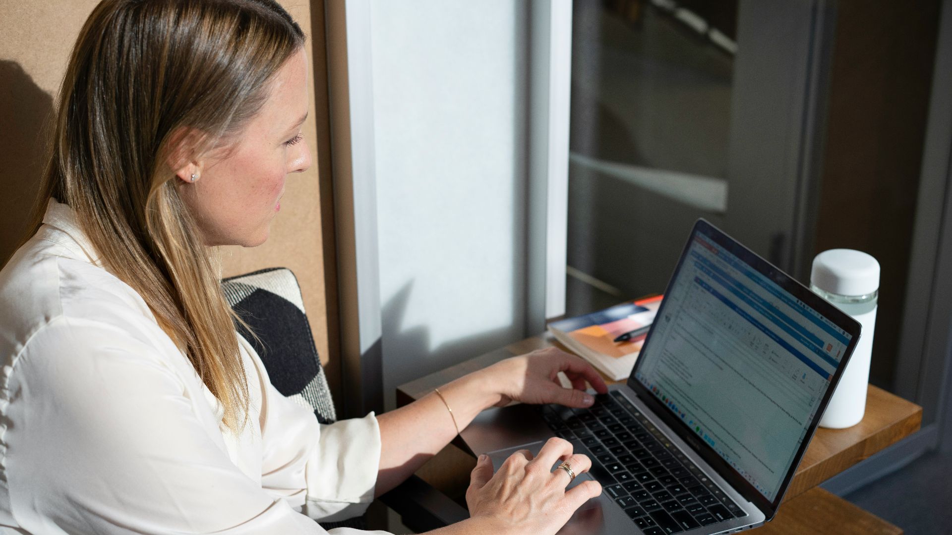 woman in white long sleeve shirt using black laptop computer
