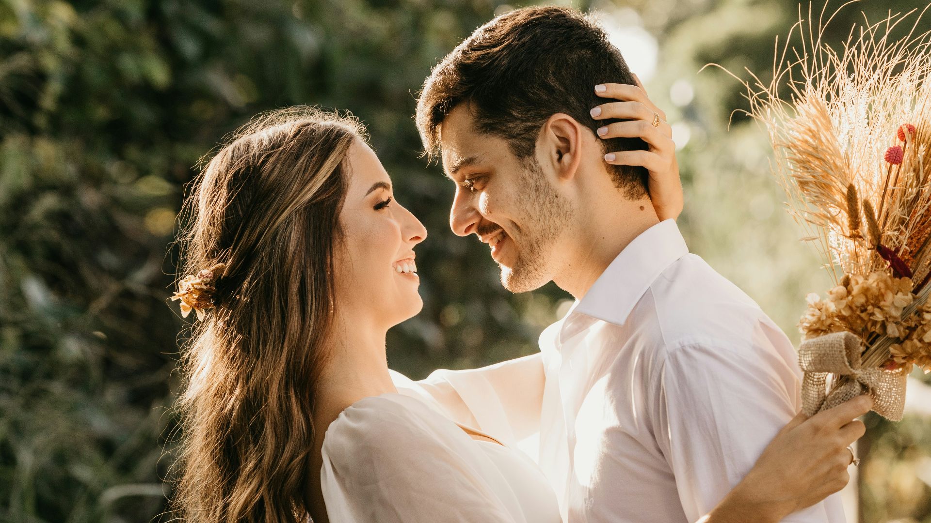 man in white dress shirt holding brown flower bouquet