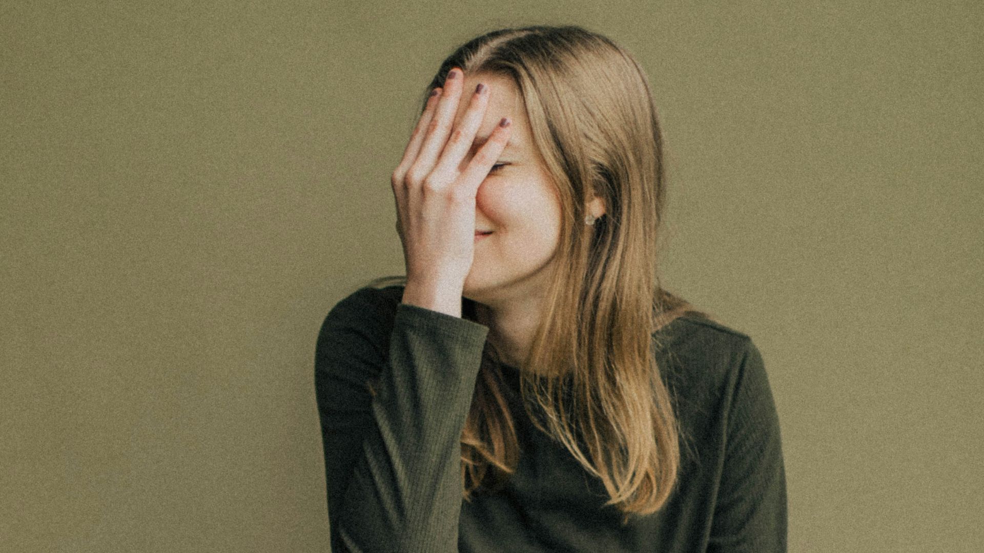 woman in black long sleeve shirt and blue denim jeans sitting on brown wooden chair