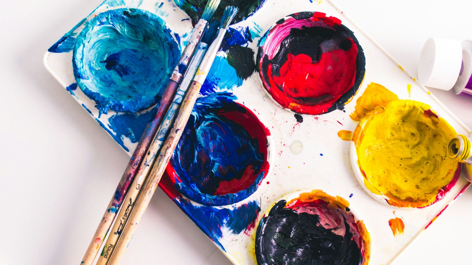 brown paint brushes on assorted-color paint palette