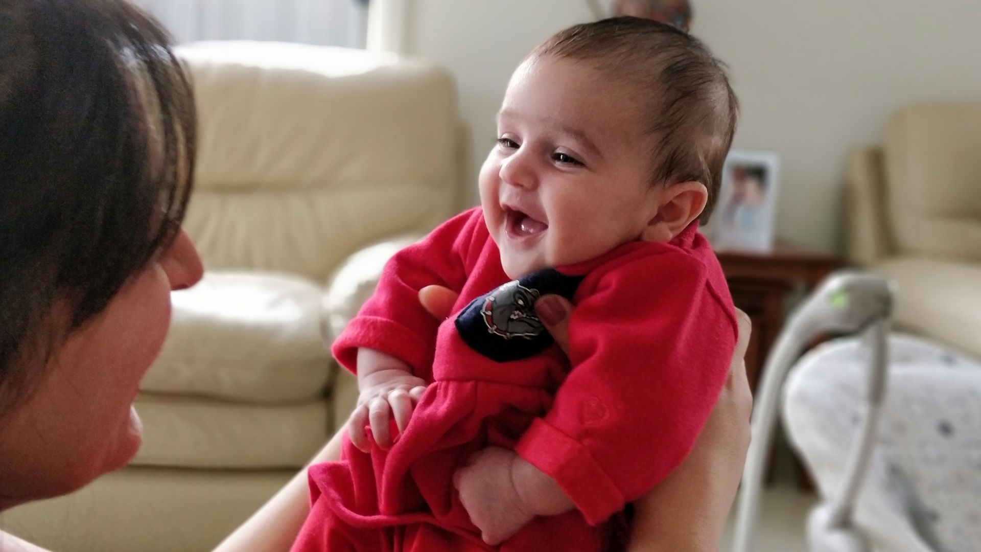 woman in pink shirt carrying child in black and white shirt