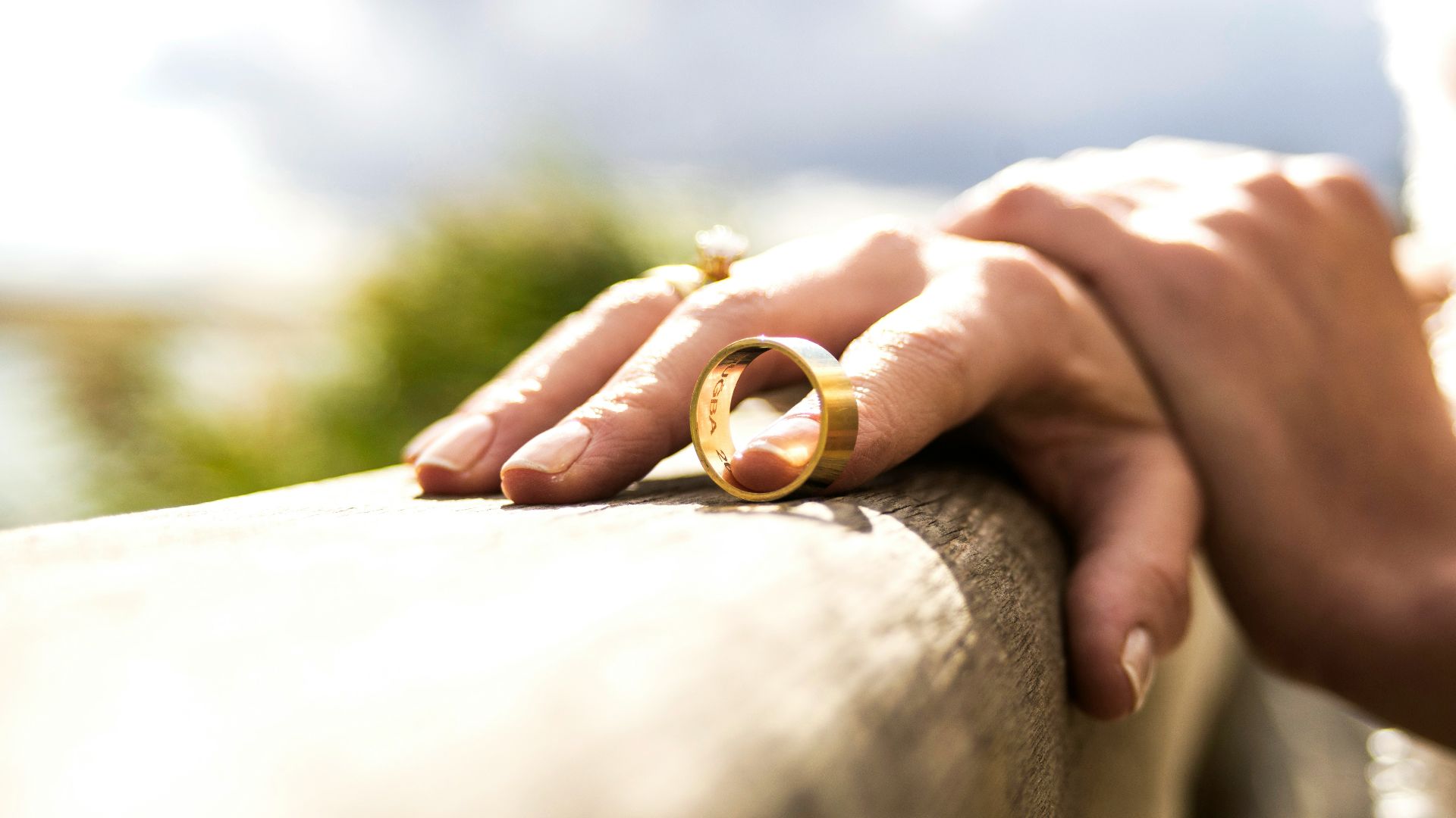 person holding gold wedding band