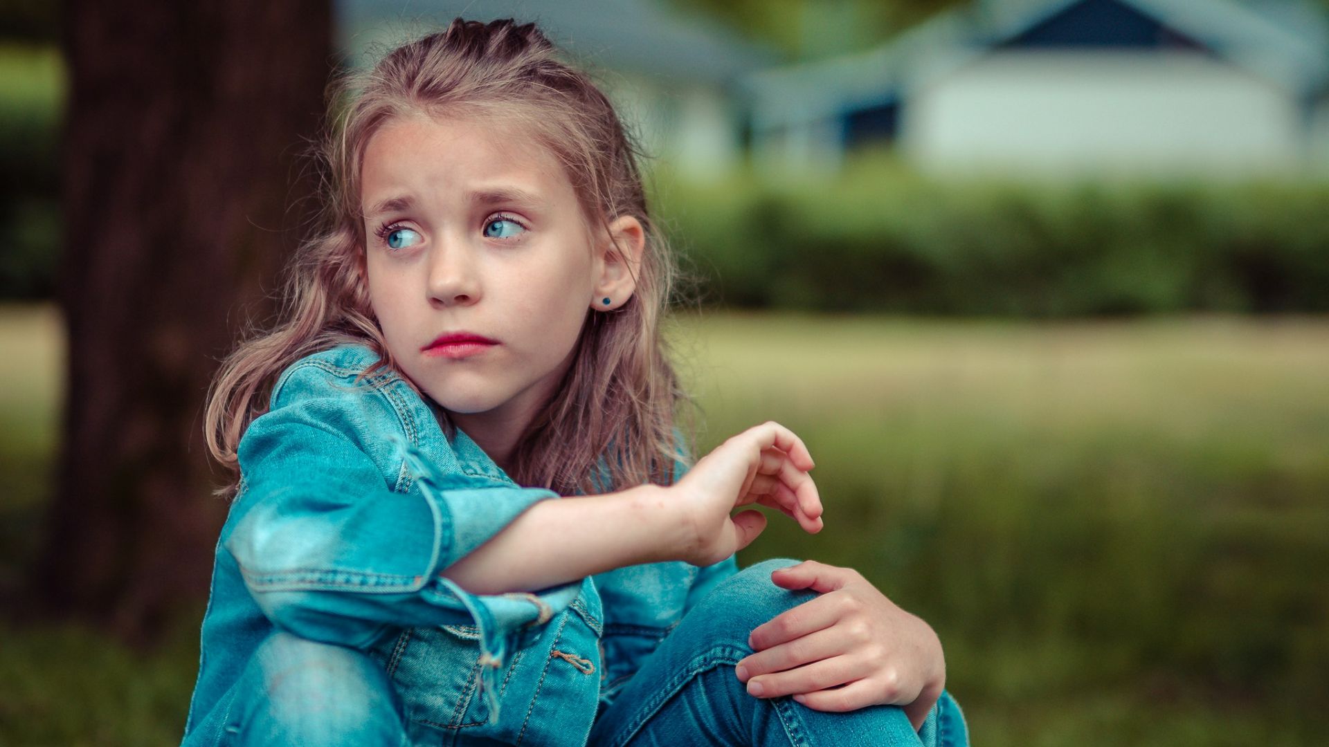 selective focus photography of girl sitting near tree