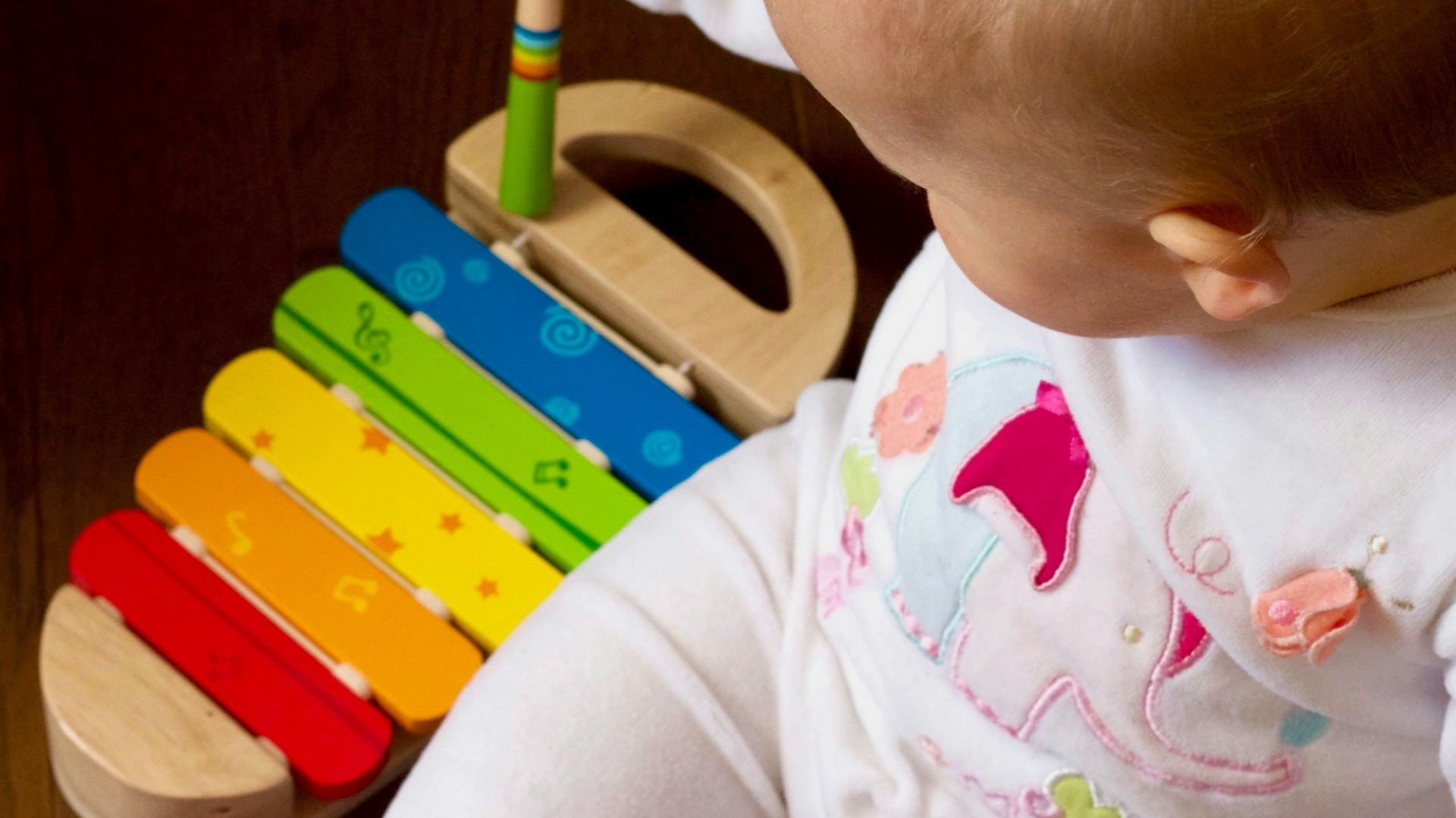 baby playing multicolored xylophone toy