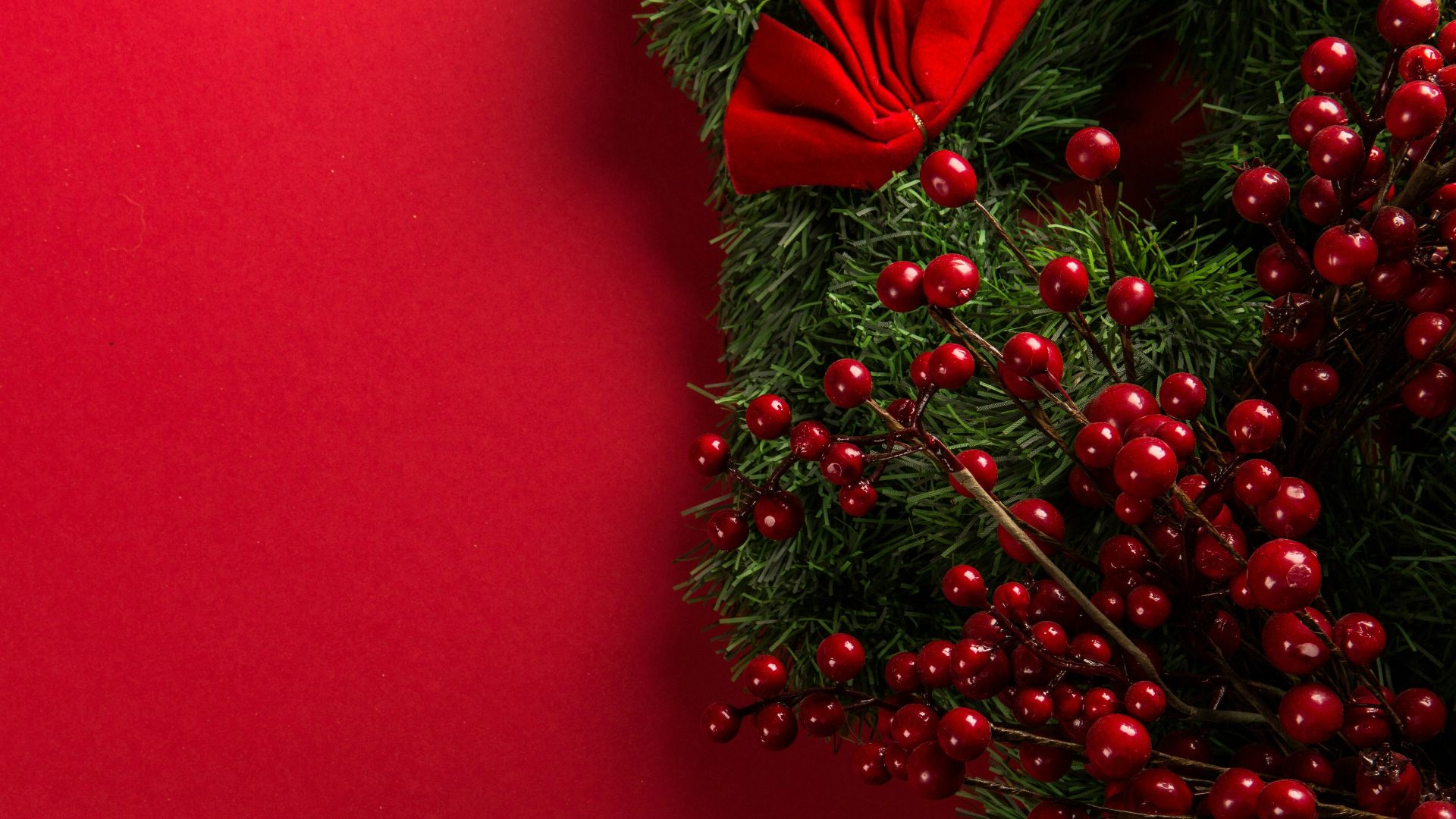 a close up of a christmas wreath on a red background