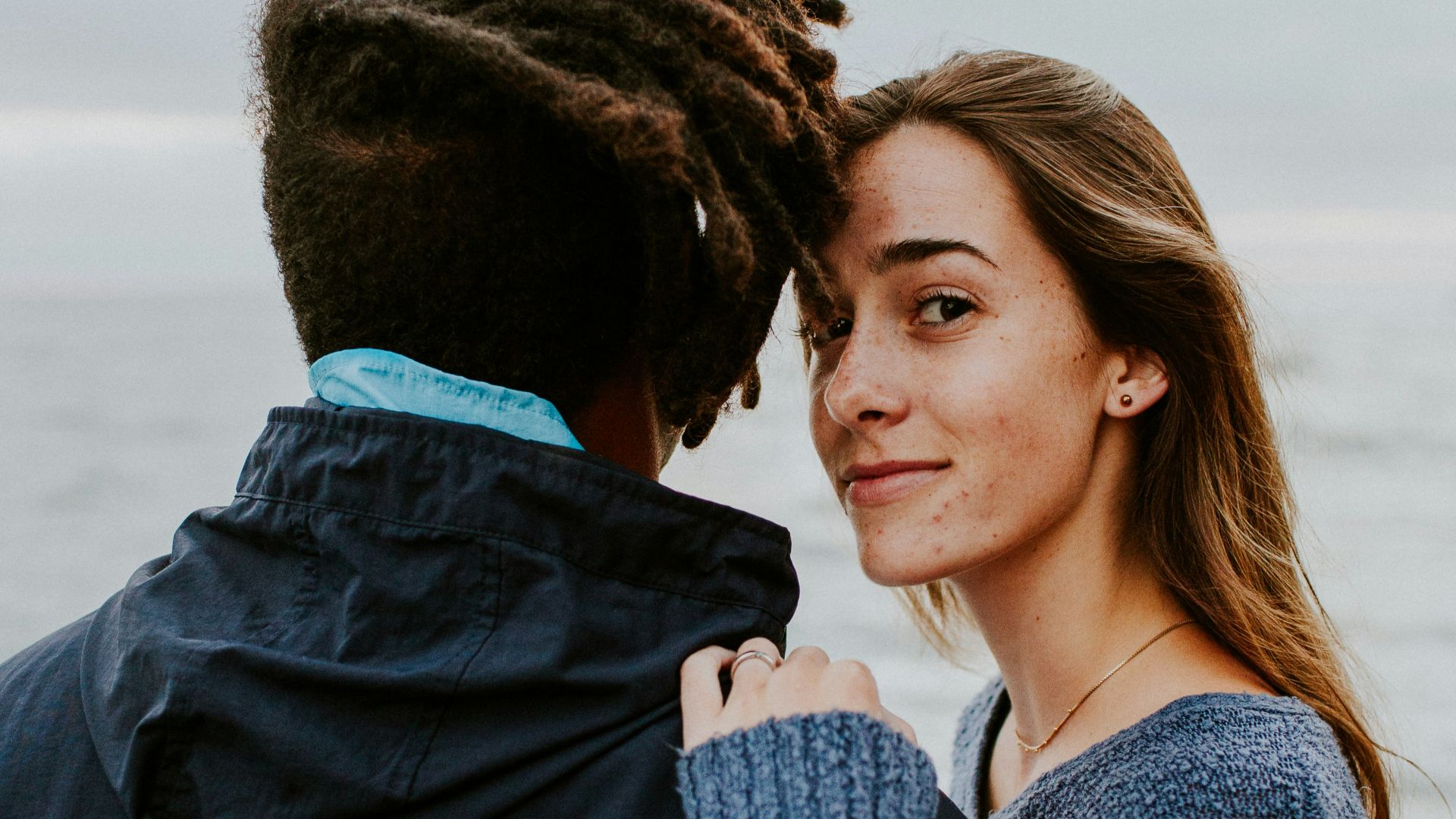 woman in blue long sleeve shirt beside woman in gray long sleeve shirt