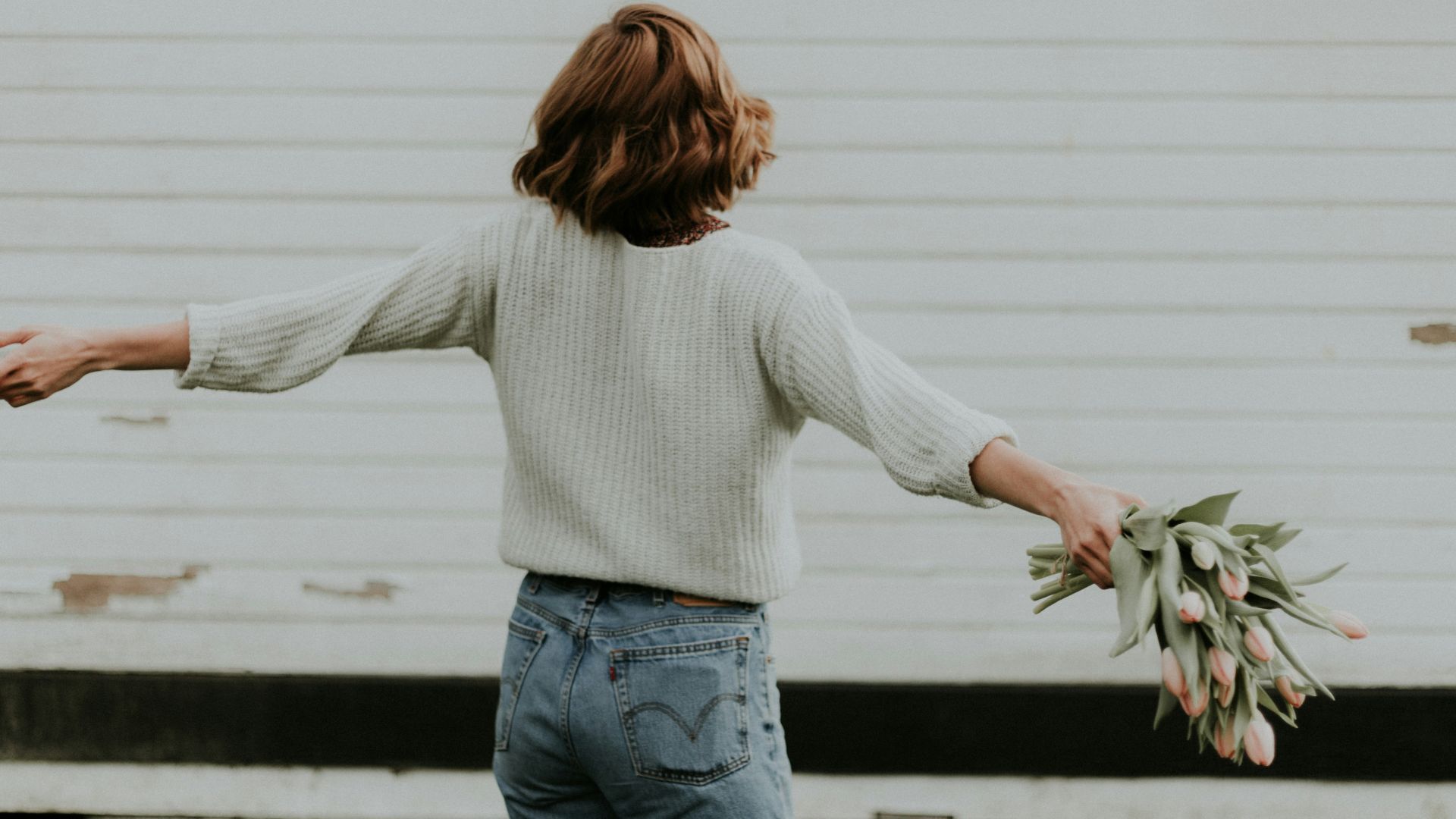 woman holding pink petaled flower