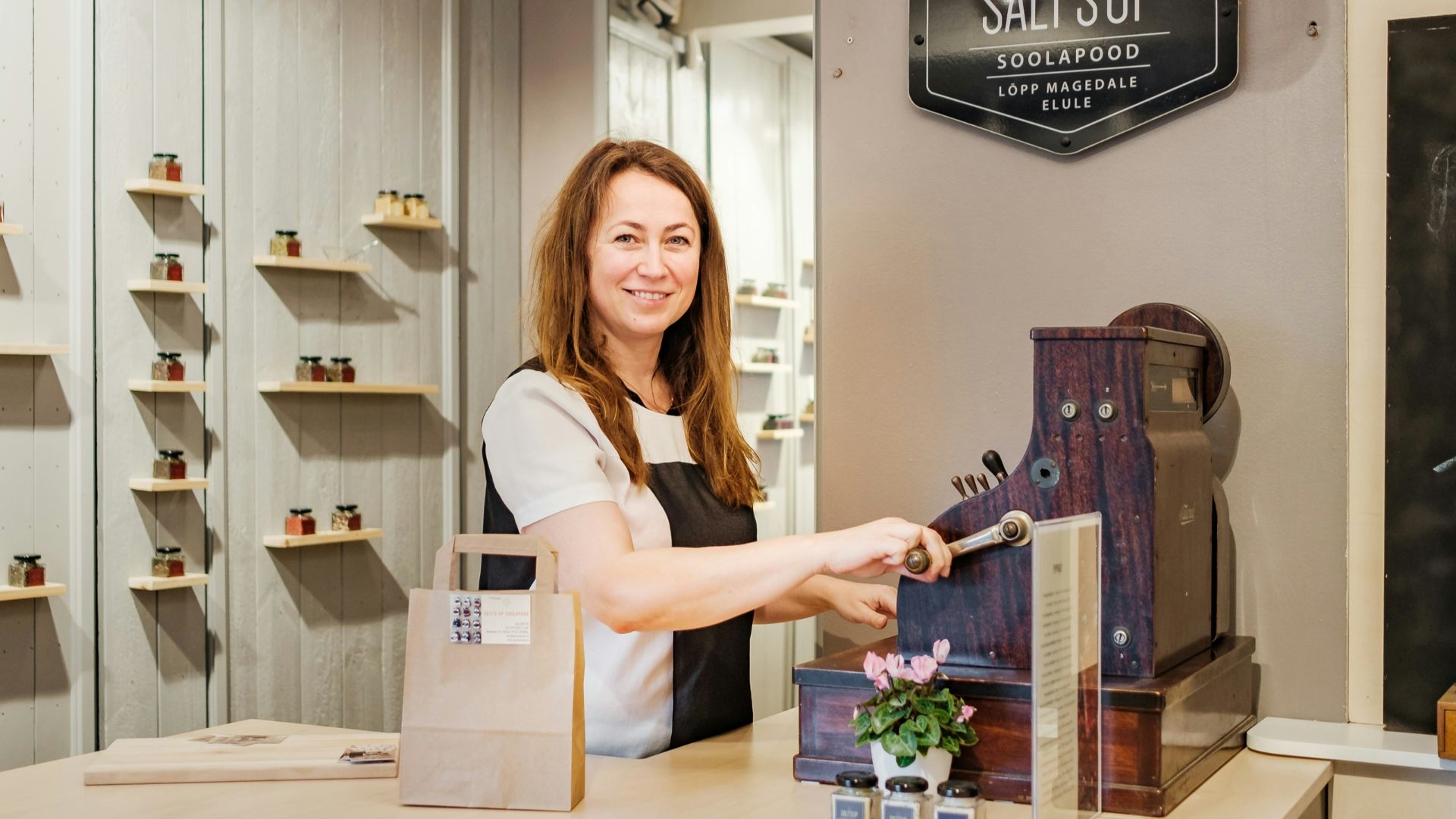 woman in white shirt standing beside brown wooden table