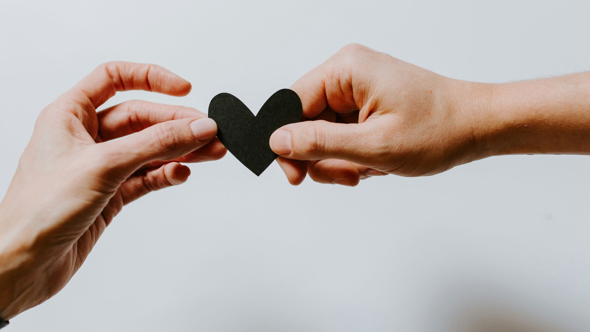 two person holding papercut heart