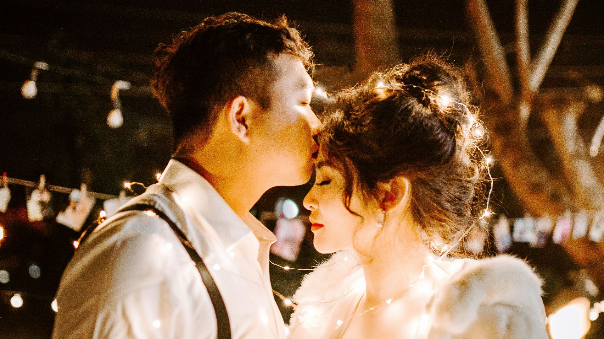 man kissing woman's forehead