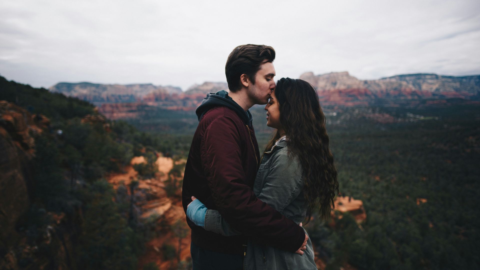 man kissing woman's forehead
