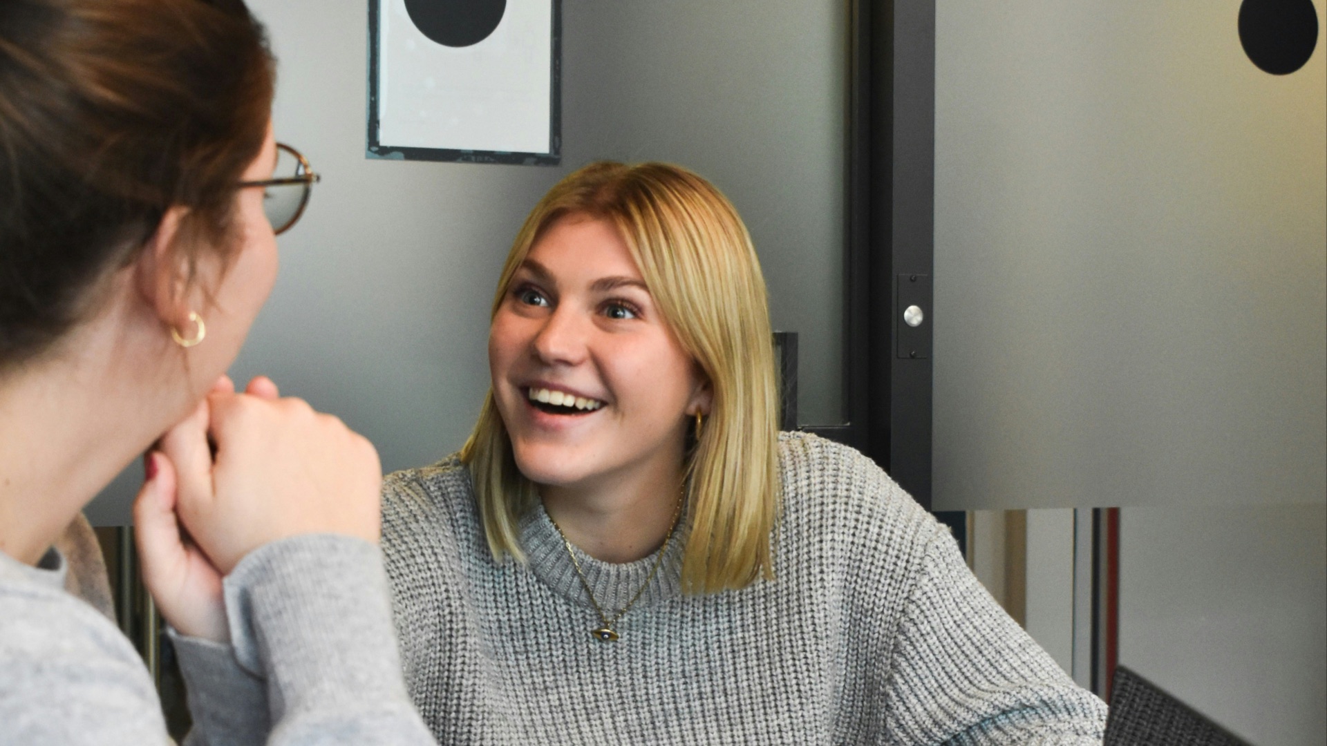 woman in gray sweater sitting beside woman in gray sweater
