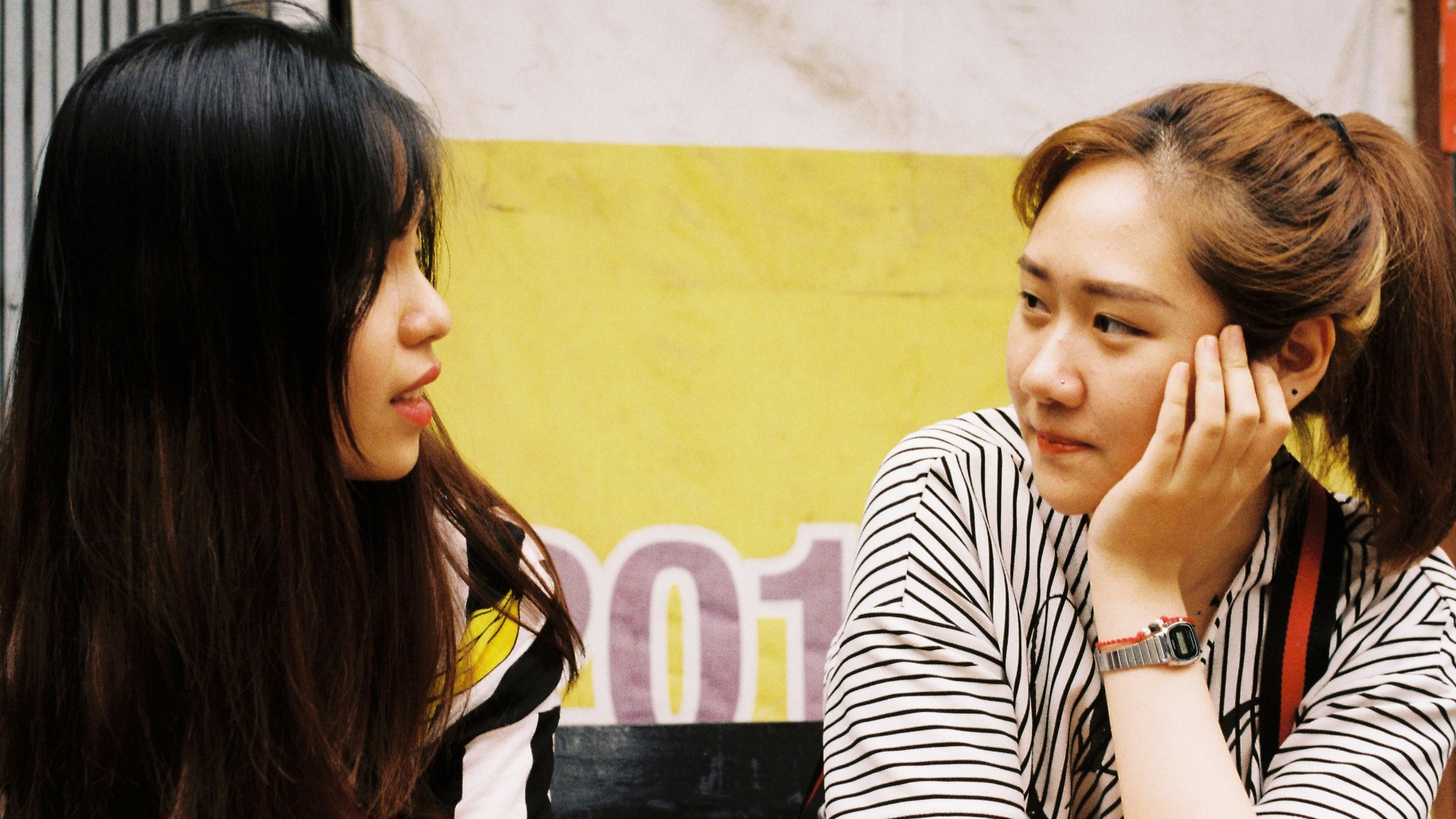 woman in white-and-black striped tops looking each other