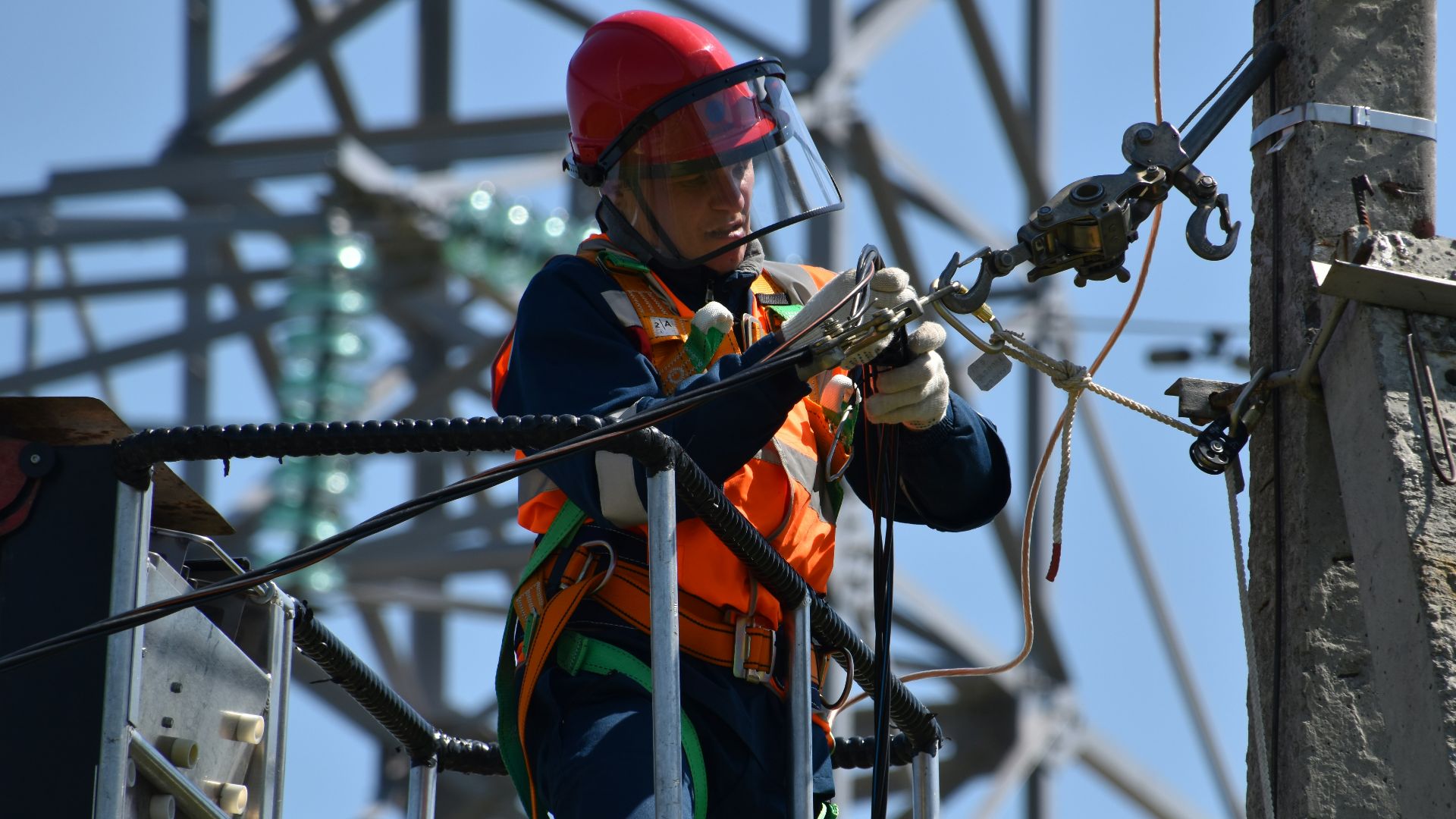 shallow focus photo of man fixing steel cable