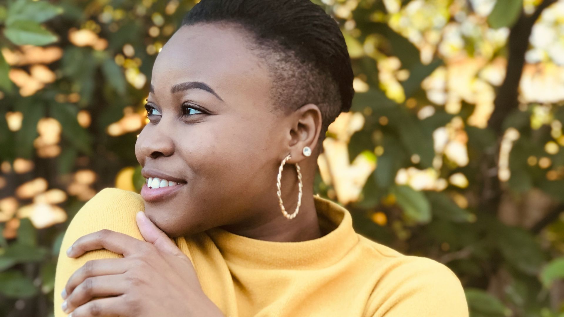 woman in yellow shirt holding yellow fruit