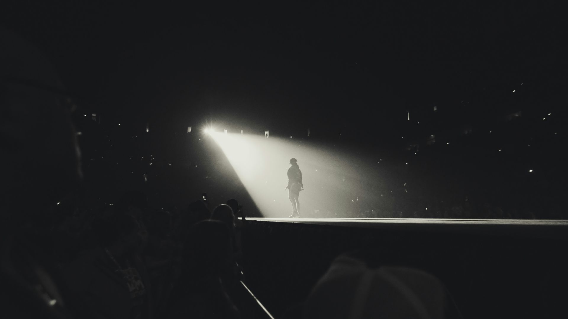 a black and white photo of a person standing in the dark