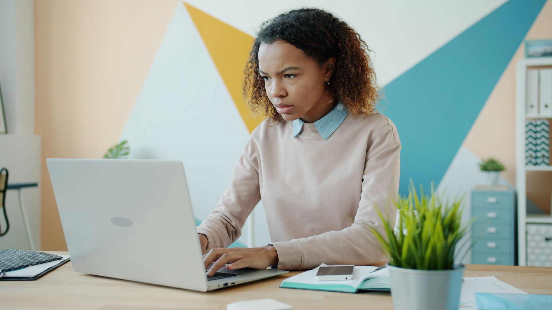 Young woman concentrating while working on a laptop.