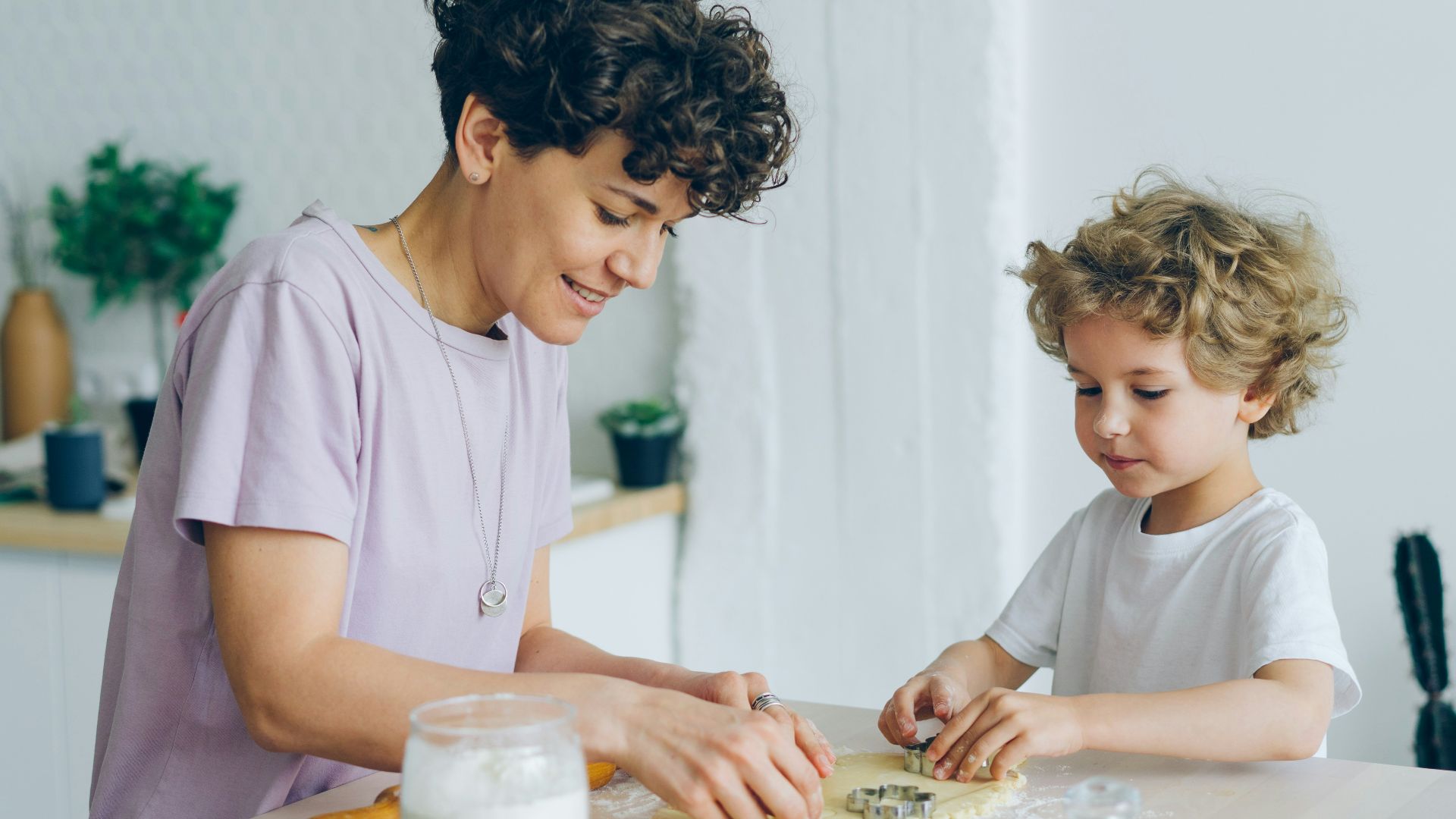 a woman and a child are making cookies
