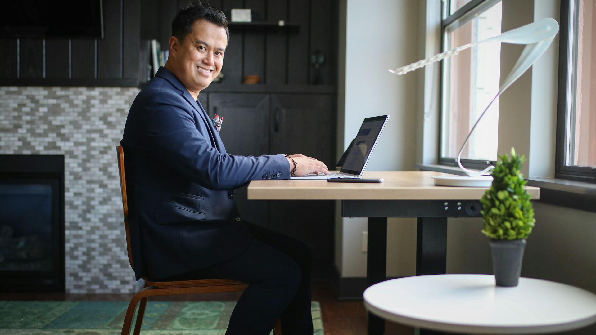 man in black dress shirt and black pants sitting on chair