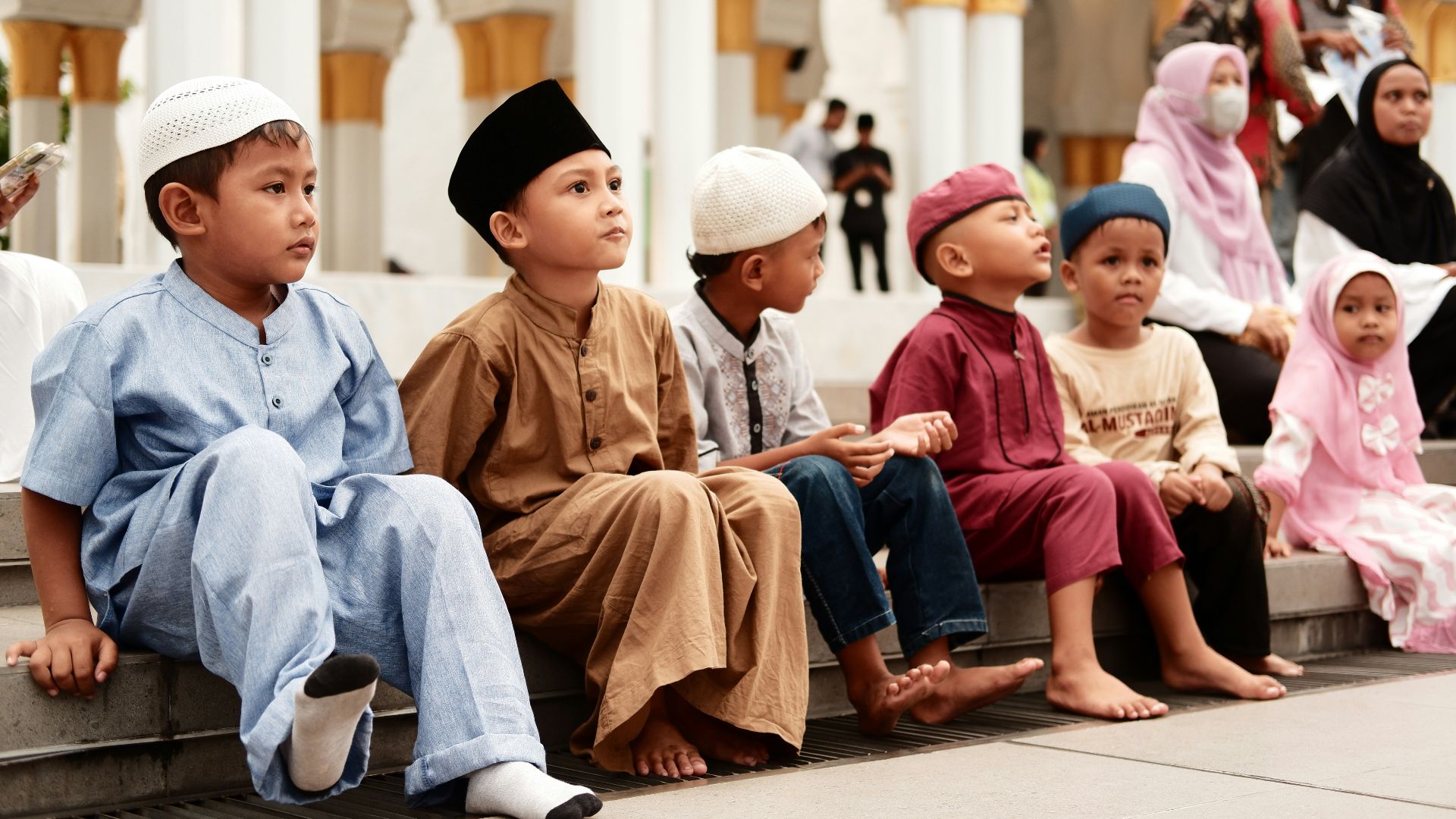 a group of children sitting on a step in front of a building