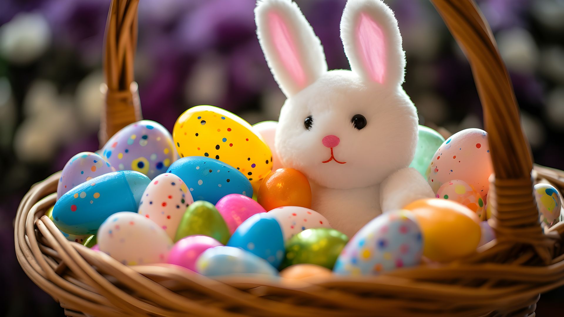 a stuffed rabbit sitting in a basket filled with eggs